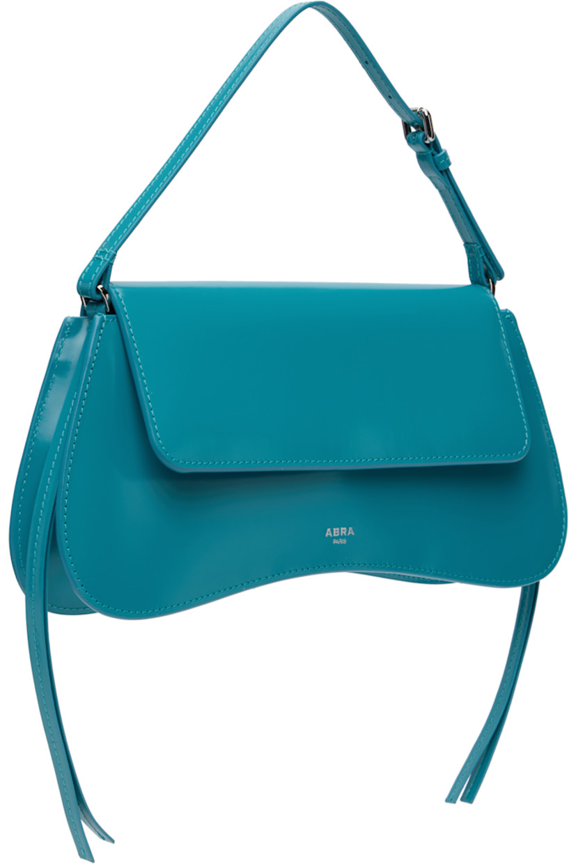 Polished leather top handle bag.

· Adjustable carry handle
· Silver-tone logo stamp at face
· Extended trim at sides
· Curved base
· Magnetic flap
· Patch pocket and D-ring at interior
· H5.25" x W11" x D2" 

Supplier color: Blue
