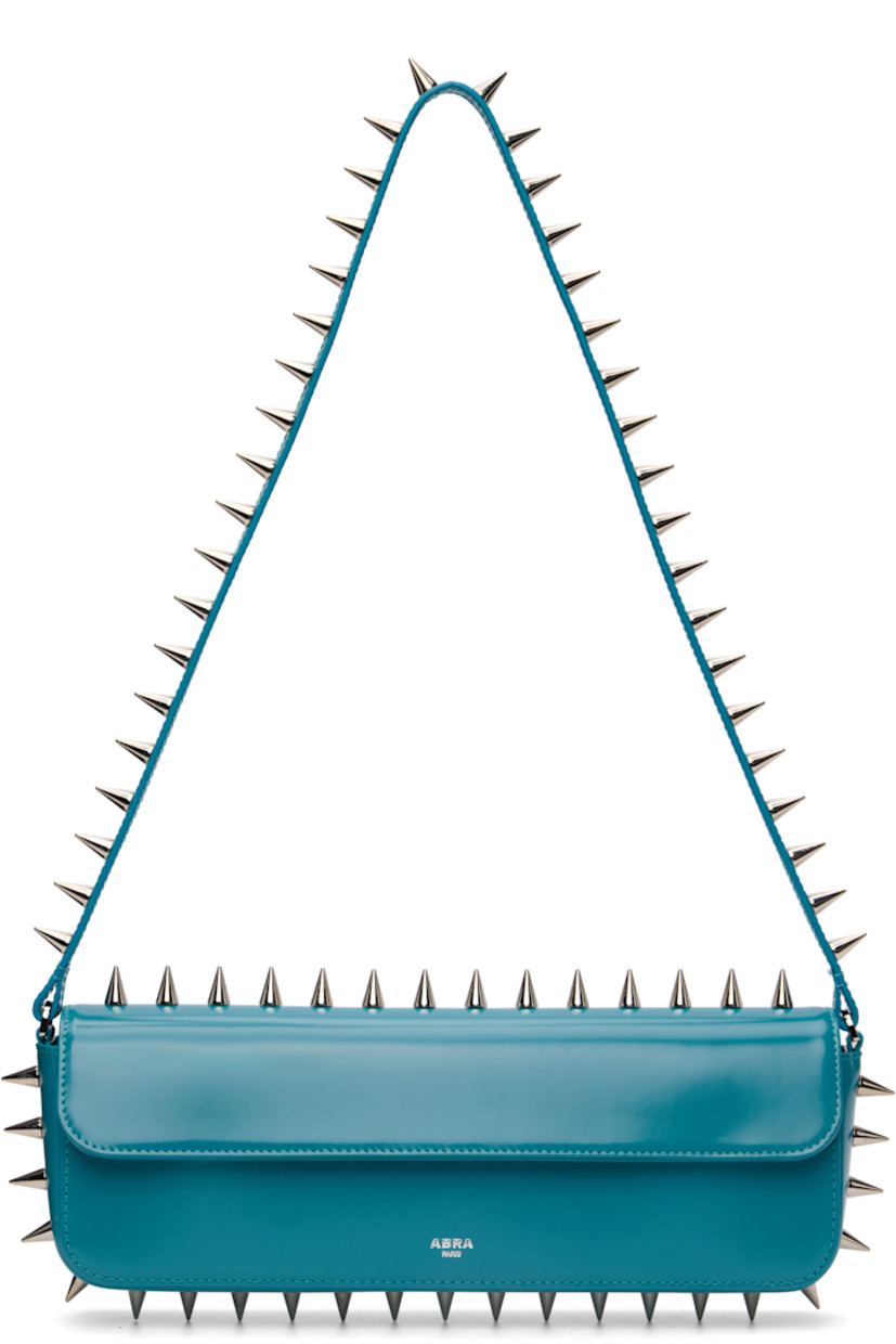 Structured polished leather shoulder bag.

· Studs throughout
· Fixed shoulder strap
· Silver-tone logo stamp at face
· Magnetic flap
· Patch pocket and D-ring at interior
· Silver-tone hardware
· H4" x W11.75" x D2"

Supplier color: Blue