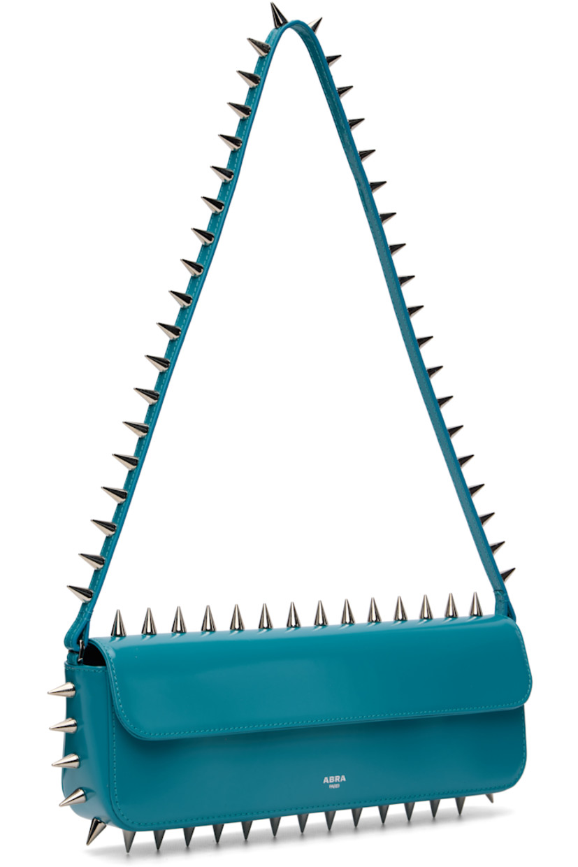 Structured polished leather shoulder bag.

· Studs throughout
· Fixed shoulder strap
· Silver-tone logo stamp at face
· Magnetic flap
· Patch pocket and D-ring at interior
· Silver-tone hardware
· H4" x W11.75" x D2"

Supplier color: Blue