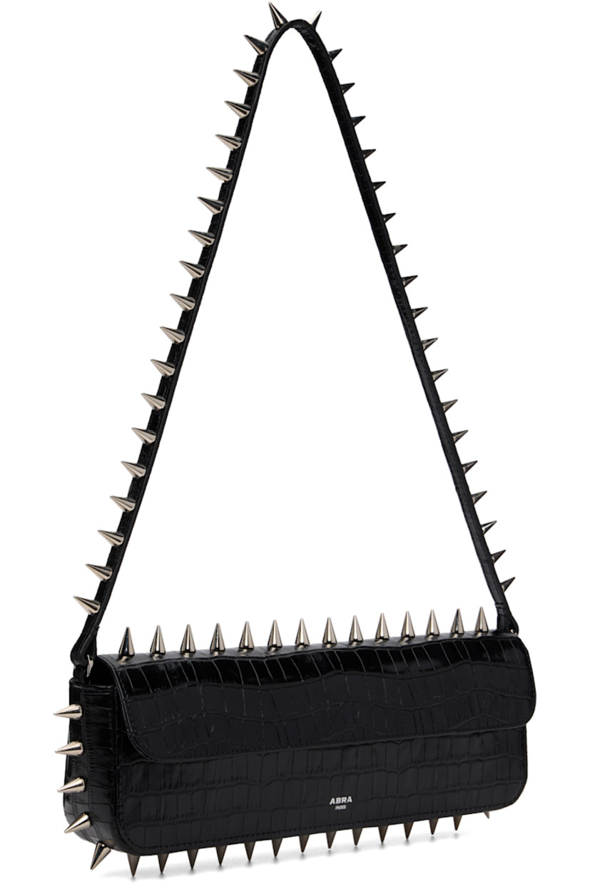 Structured croc-embossed leather messenger bag.

· Studs throughout
· Fixed shoulder strap
· Silver-tone logo stamp at face
· Magnetic flap
· Patch pocket and D-ring at interior
· Silver-tone hardware
· H4" x W11.75" x D2"

Supplier color: Black crocco