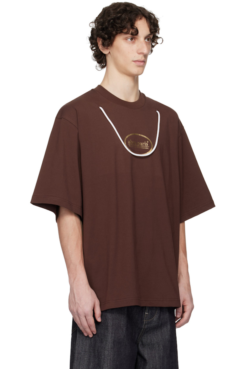 Cotton jersey T-shirt.

· Rib-knit crewneck
· Logo printed at chest
· Cord trim at front
· Dropped shoulders

Supplier color: Brown