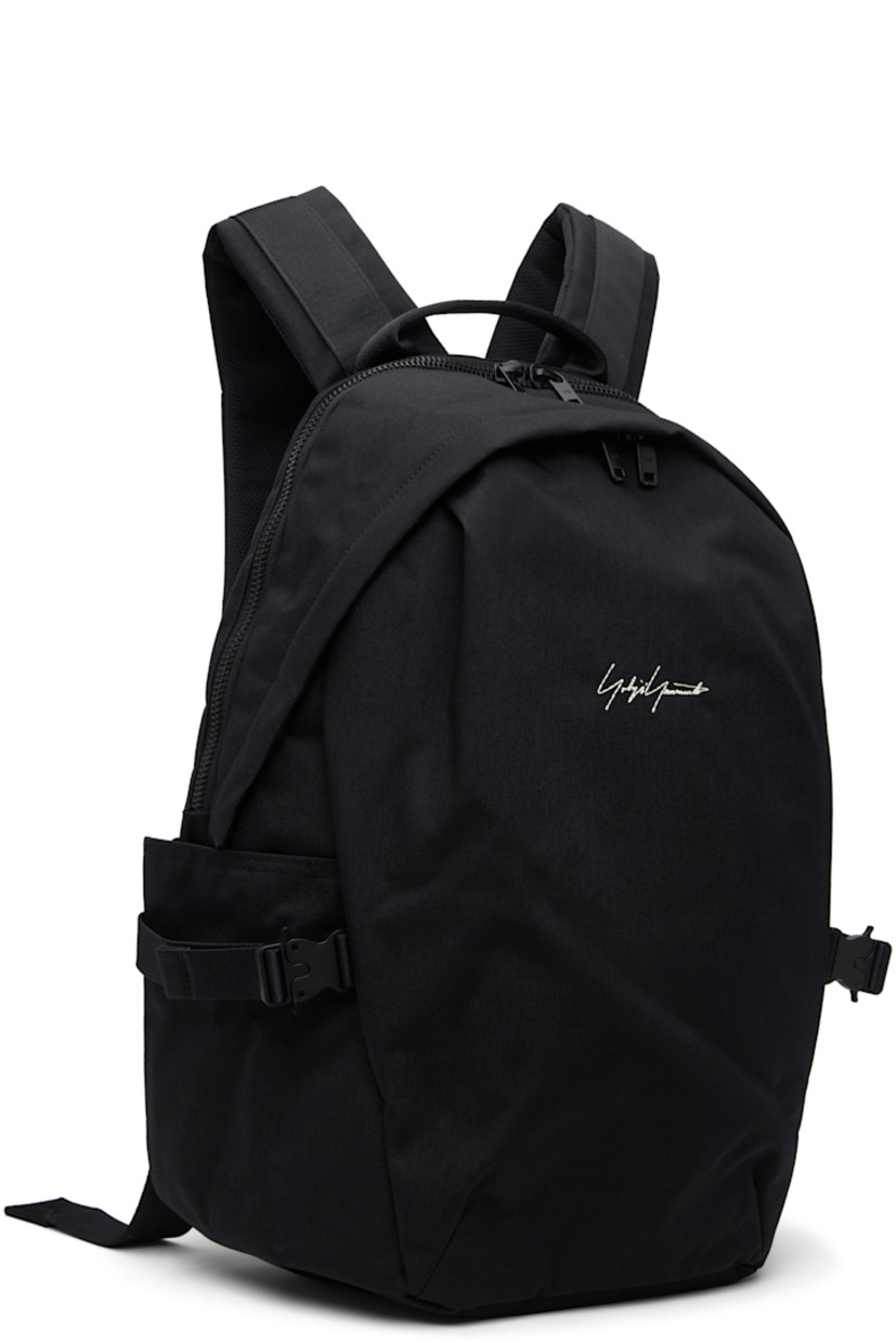 Nylon canvas backpack. Zip pocket at base with detachable waterproof bag cover.

· Carry handle at top
· Padded shoulder straps with D-ring
· Sternum strap with rollercoaster buckle
· Logo embroidered at face
· Two-way zip compartment with pocket at face
· Pocket with rollercoaster buckle at sides
· Two-way zip closure at main compartment
· Padded laptop compartment and patch pocket
· Twill lining
· H17" x W16" x D5"

Part of the Yohji Yamamoto Y-3 KURO collection.

Supplier color: Black