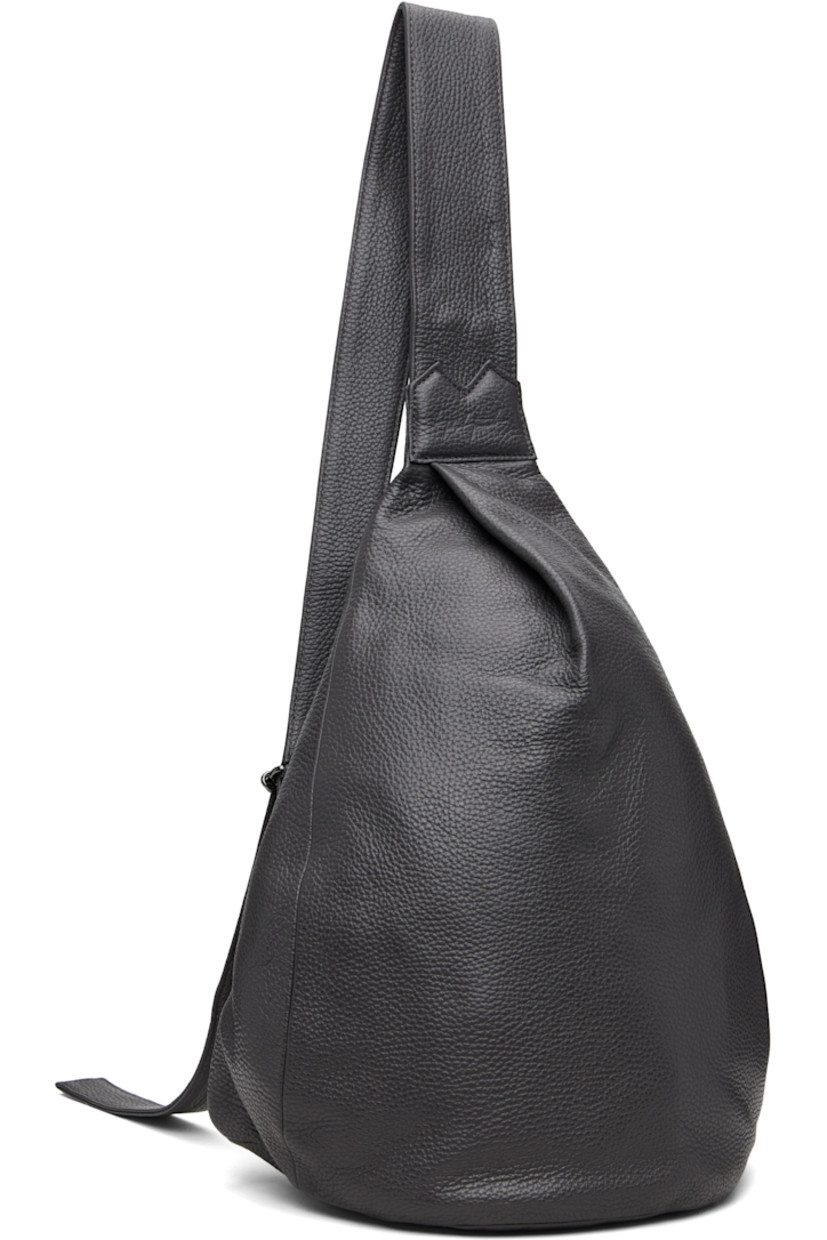 Grained leather shoulder bag.

· Convertible and adjustable crossbody strap
· Converts from left or right shoulder
· Pleat and embossed logo at face
· Zip closure at back face
· Zip pocket at interior
· Twill lining
· H15" x W12" x D5"

Part of the discord YOHJI YAMAMOTO collection.

Supplier color: Dark Grey