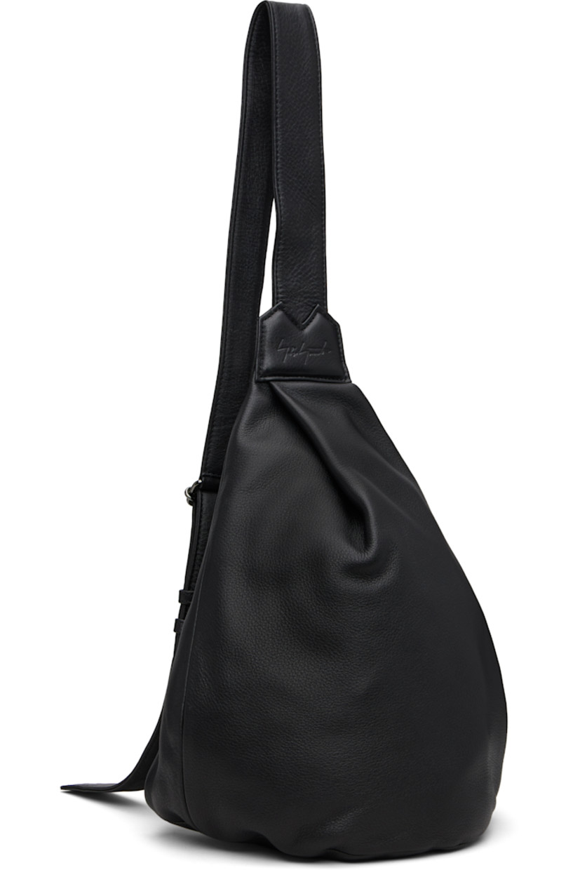 Grained leather shoulder bag.

· Convertible and adjustable crossbody strap
· Converts from left or right shoulder
· Pleat and embossed logo at face
· Zip closure at back face
· Zip pocket at interior
· Twill lining 
· H13" x W9" x D4.5"

Part of the discord YOHJI YAMAMOTO collection.

Supplier color: Black