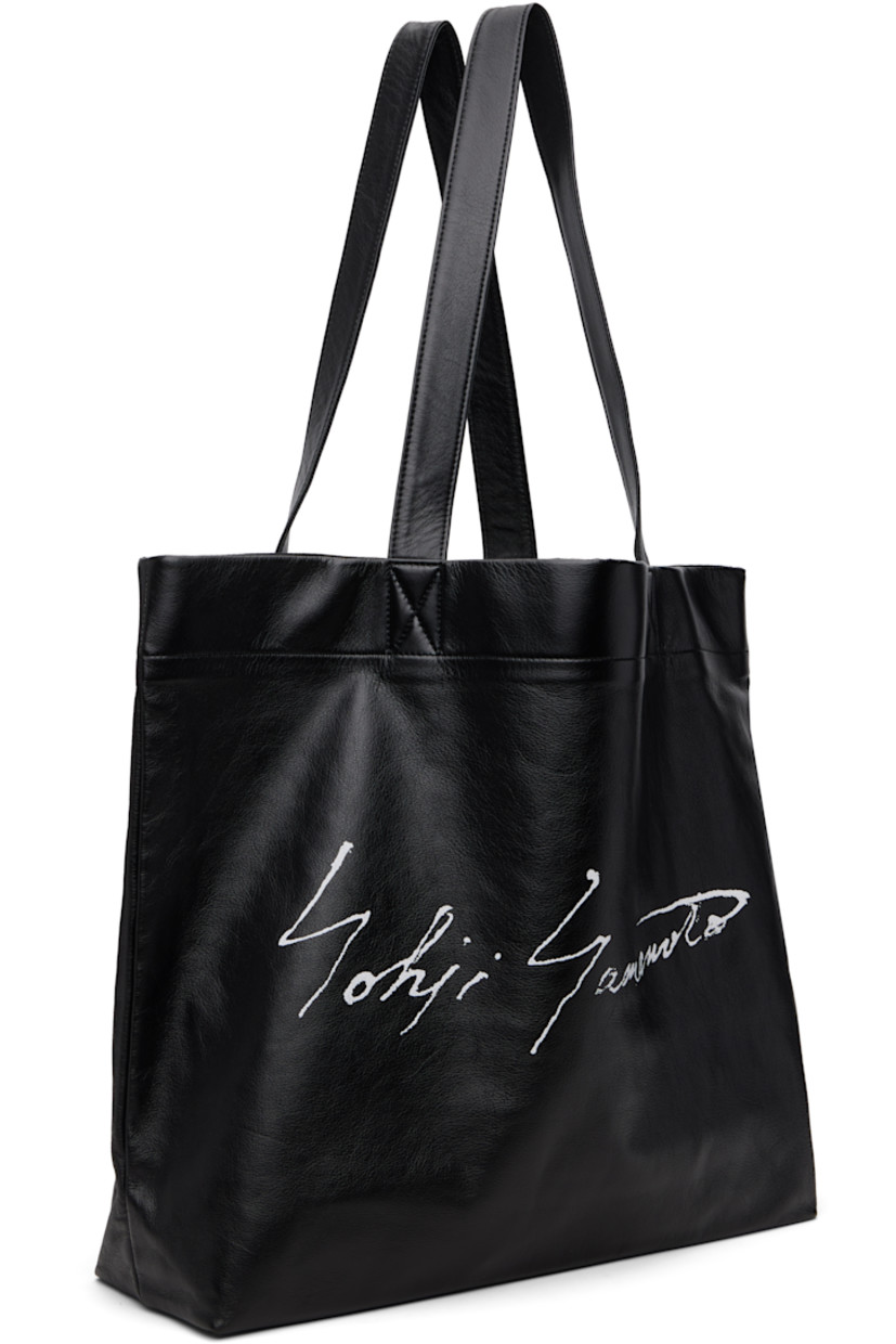 Grained leather tote.

· Fixed shoulder straps
· Logo printed at face
· Patch pocket at interior
· Twill lining
· H14" x W19" x D5"

Part of the discord YOHJI YAMAMOTO collection.

Supplier color: Black
