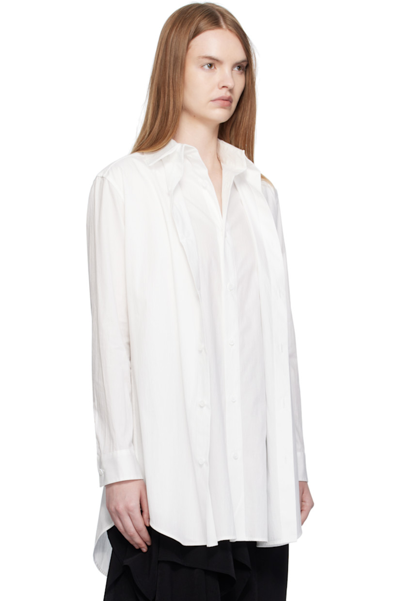 Cotton broadcloth shirt. 

· Layered construction
· Spread collar 
· Button closure
· Shirttail hem 
· Buttoned barrel cuffs
· Box pleat at back yoke 

Part of 'Yohji Yamamoto collections'.

Supplier color: Off white