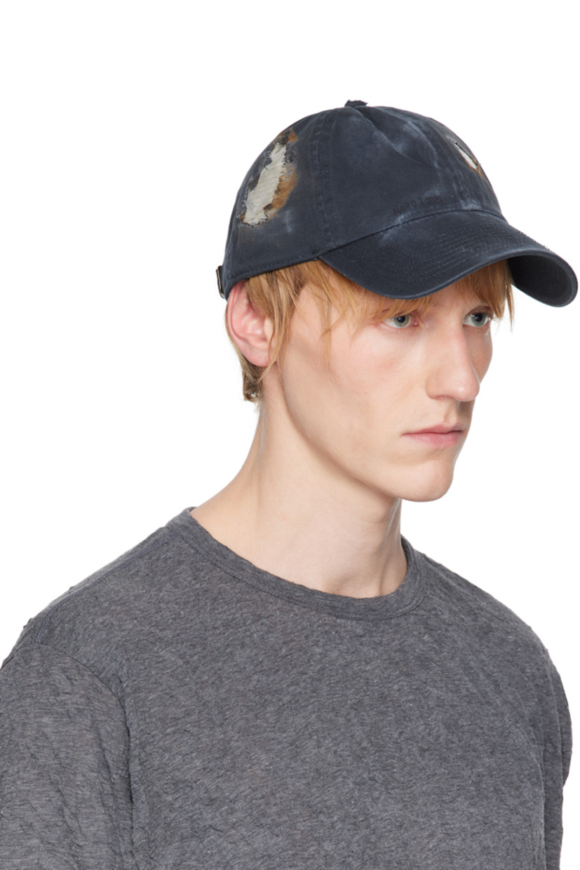 Cotton twill cap in navy. 

· Fading throughout
· Distressing with tape appliqué throughout 
· Embroidered eyelets at crown
· Text printed at front
· Cinch fastening
· Plain-woven browband
· Tape at interior

Available exclusively at SSENSE.

Supplier color: Navy