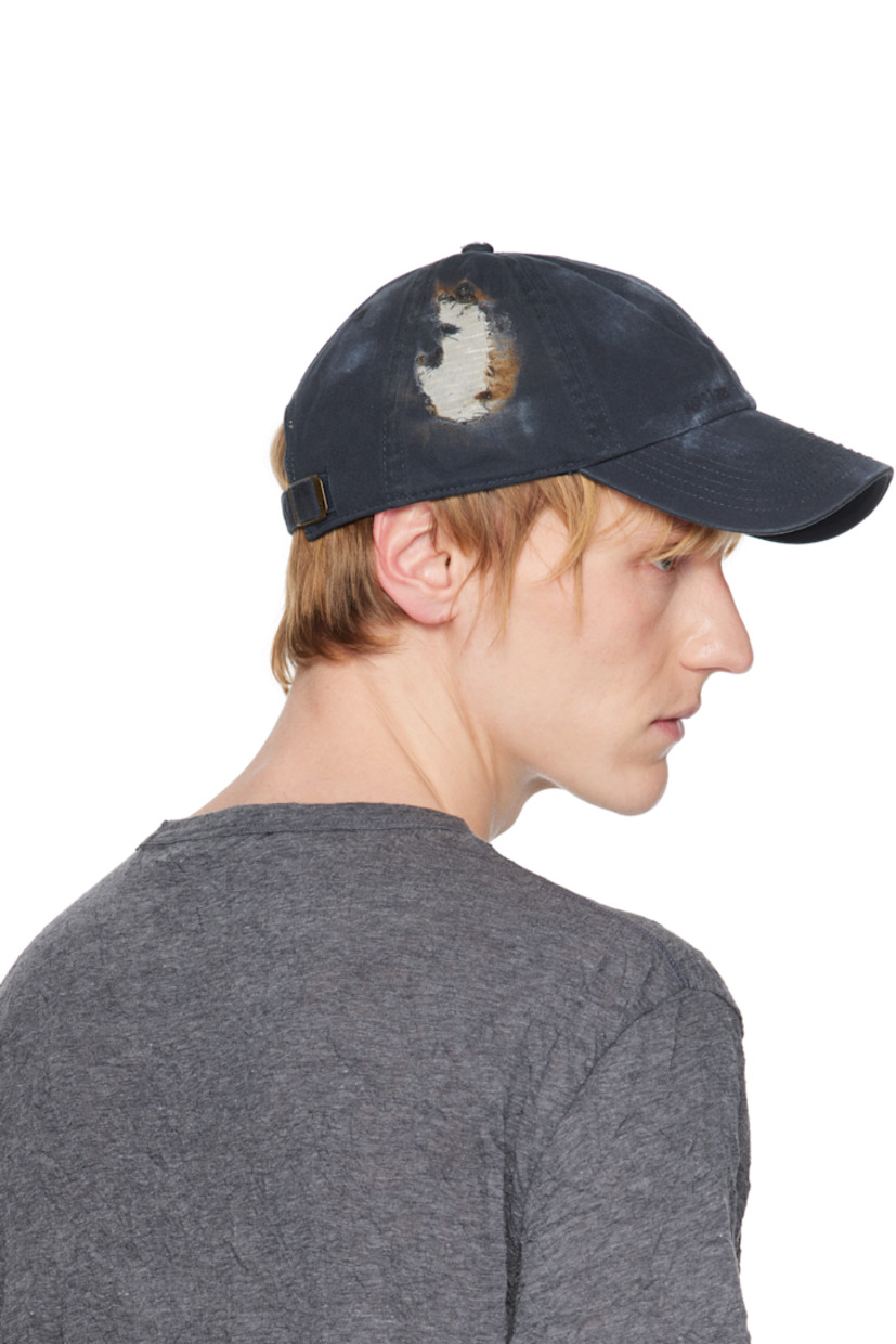 Cotton twill cap in navy. 

· Fading throughout
· Distressing with tape appliqué throughout 
· Embroidered eyelets at crown
· Text printed at front
· Cinch fastening
· Plain-woven browband
· Tape at interior

Available exclusively at SSENSE.

Supplier color: Navy