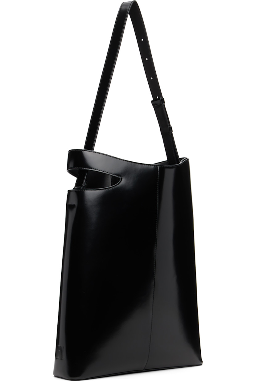 Polished leather tote.

· Adjustable shoulder strap
· Cutout and embossed logo at side
· Zip pocket at interior
· Faille lining
· H16" x W12 x D3"

Supplier color: Black