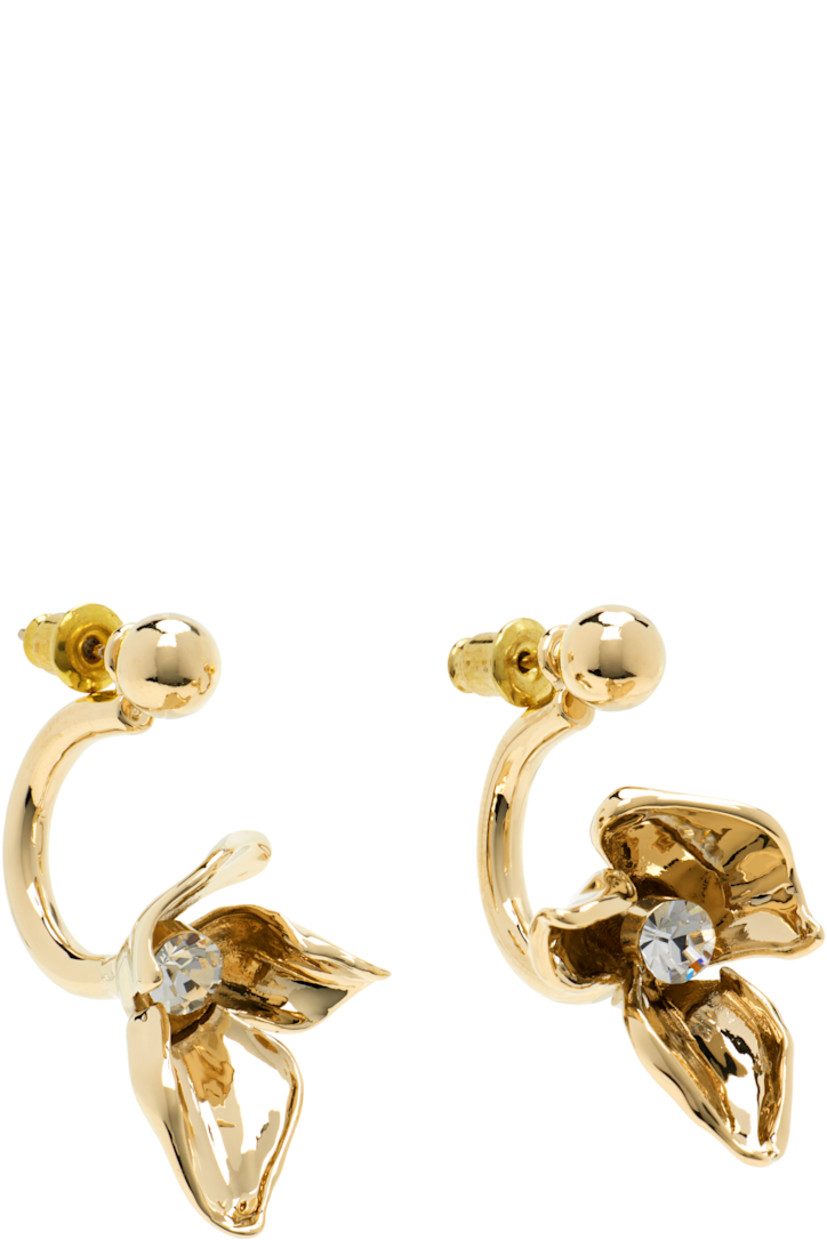 Pair of drop earrings in gold-tone brass.

· Floral graphic with bezel-set crystal at drop
· Post-stud fastening
· H1.5" x W0.75"

Supplier color: Light gold