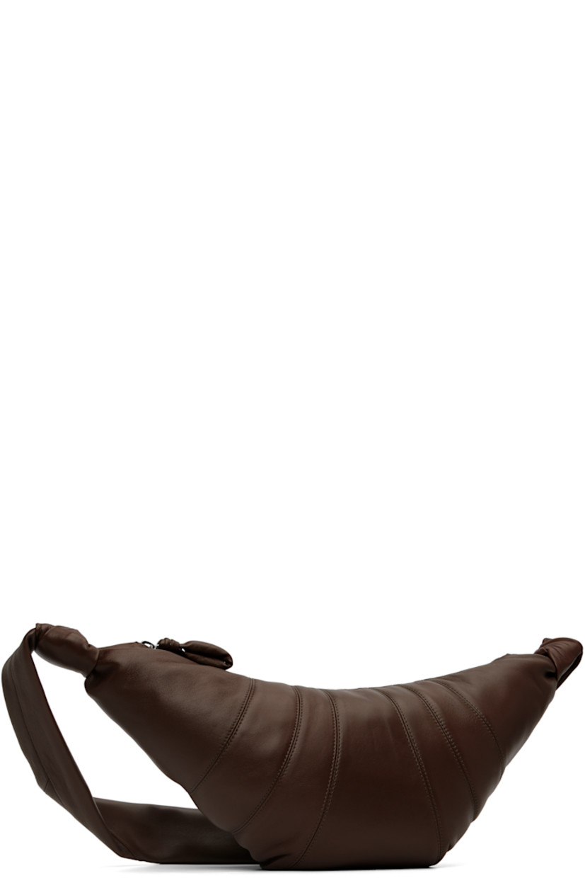 Nappa lambskin shoulder bag.

· LWG Gold-certified lambskin
· Fixed knotted crossbody strap
· Padded pull-tab at zip closure
· Patch pocket at interior
· Cotton canvas lining
· H8.5" x W18" x D2"

Supplier color: Dark Chocolate