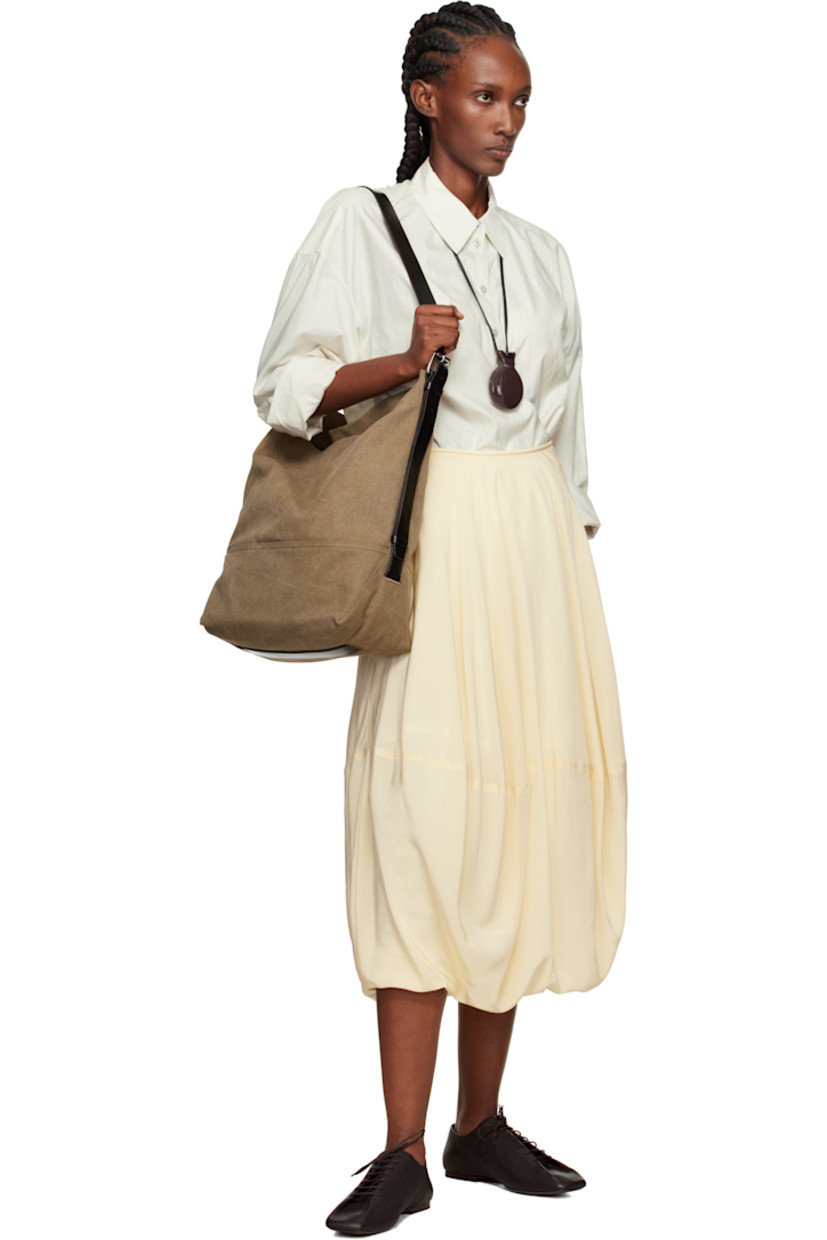 Tie-dyed cotton canvas tote. 

· Vegetable-tanned buffed leather trim throughout
· Adjustable and detachable shoulder strap
· Lanyard-clasp closure
· Zip pocket at interior 
· H15.5" x W17.5" x D6"

Supplier color: Sisal