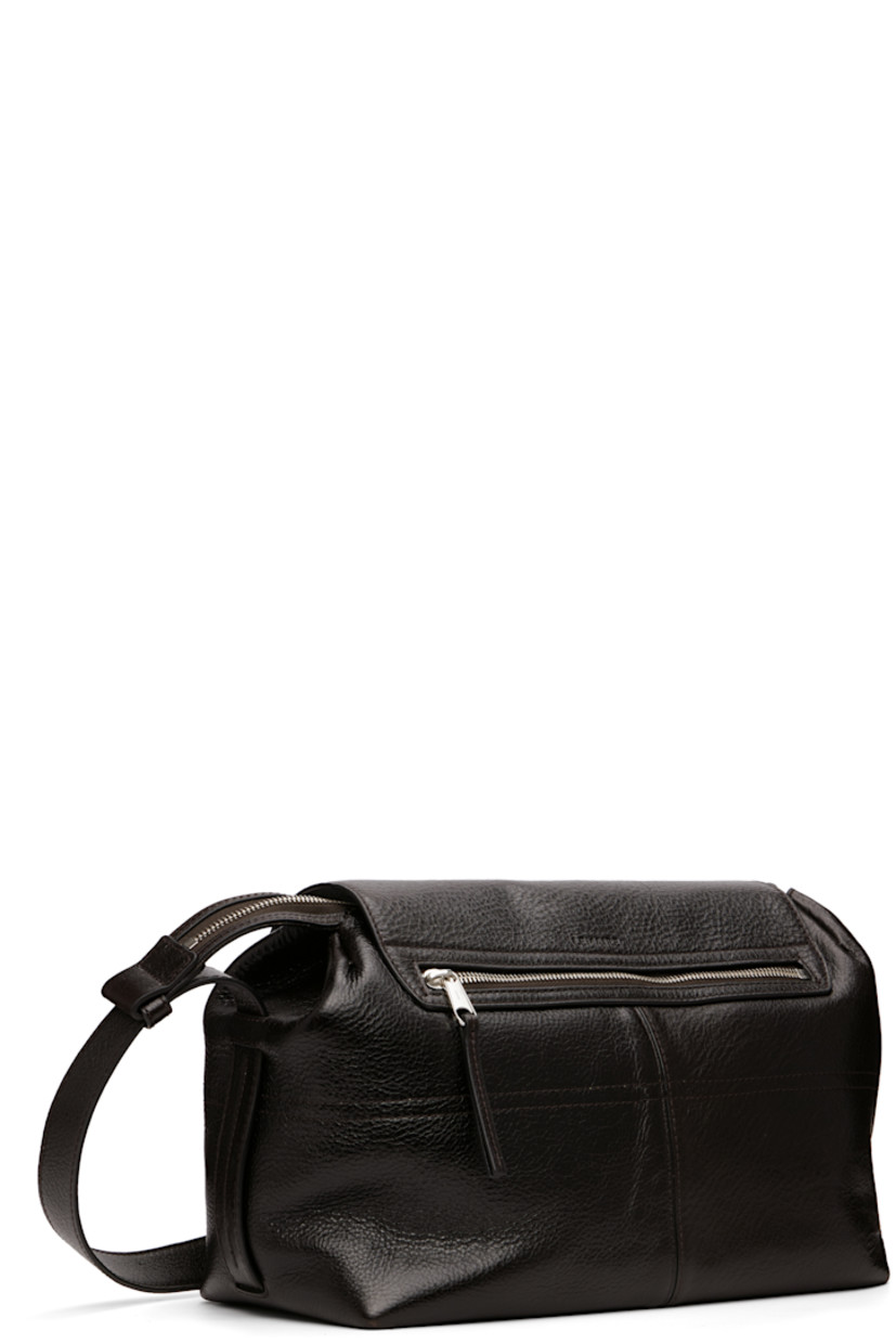 Vegetable-tanned grained leather messenger bag.

· LWG Gold-certified leather
· Adjustable crossbody strap
· Flap pockets at face
· Zip pocket and embossed logo at back face
· Press-release flap
· Zip closure
· Suede lining
· H8.5" x W13" x D7"

Supplier color: Espresso