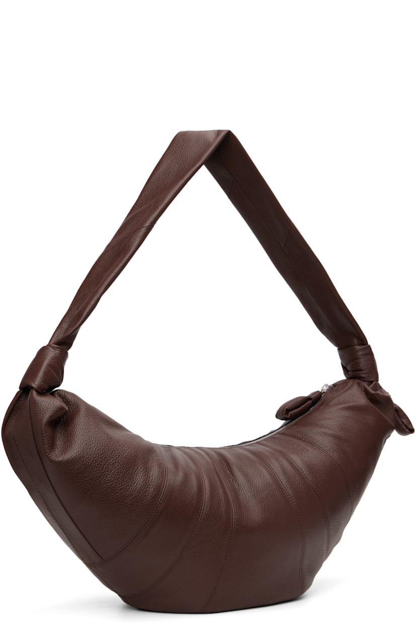 Grained leather messenger bag.

· LWG Gold-certified lambskin
· Fixed knotted crossbody strap
· Zip pocket with padded pull-tab at side
· Padded pull-tab at zip closure
· Patch pocket at interior
· Detachable zip pouch-on-lanyard at interior
· Cotton canvas lining
· H11" x W23" x D2.5"

Supplier color: Roasted Pecan