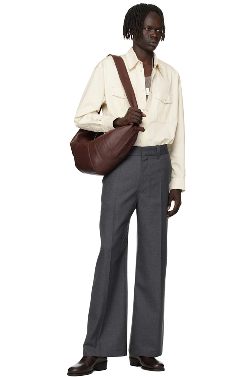 Grained leather messenger bag.

· LWG Gold-certified lambskin
· Fixed knotted crossbody strap
· Zip pocket with padded pull-tab at side
· Padded pull-tab at zip closure
· Patch pocket at interior
· Detachable zip pouch-on-lanyard at interior
· Cotton canvas lining
· H11" x W23" x D2.5"

Supplier color: Roasted Pecan