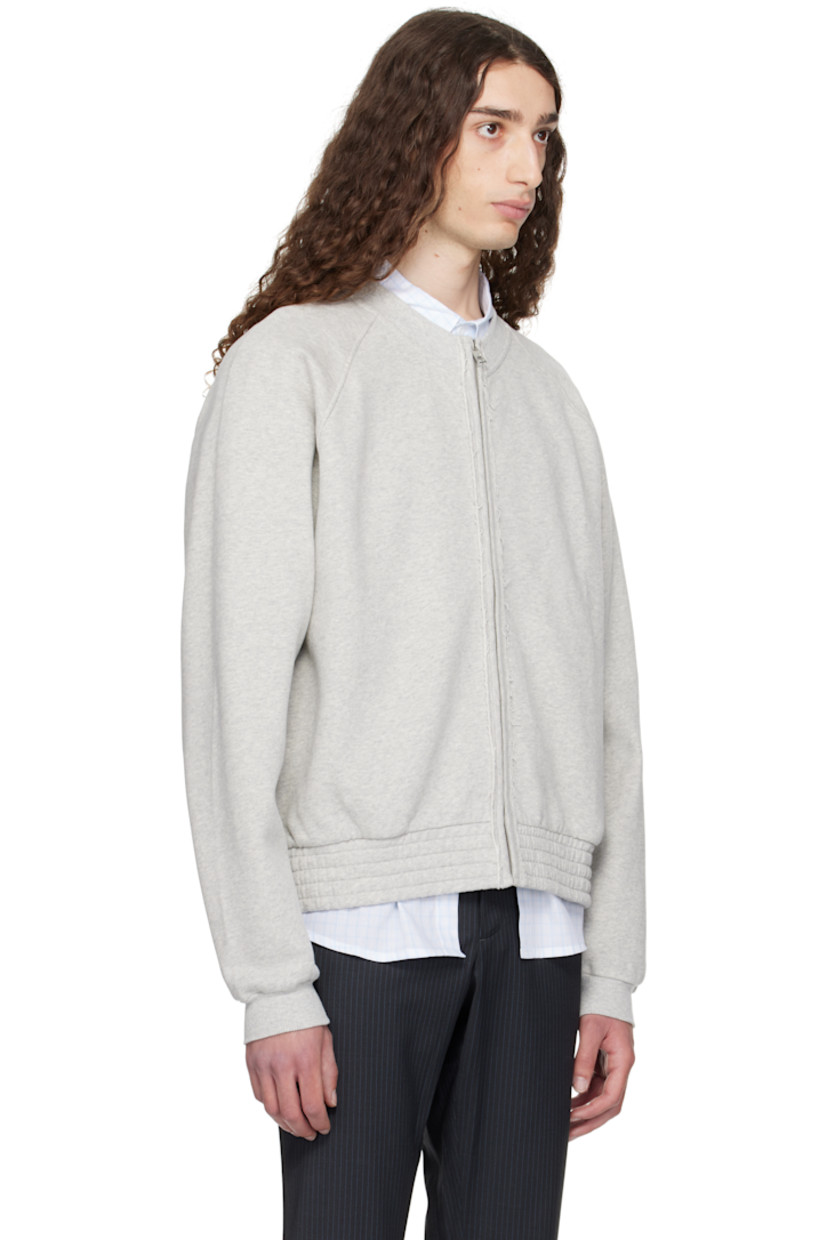 Organic cotton fleece jacket. 

· Rib-knit crewneck and cuffs
· Zip closure
· Frayed edge at placket 
· Seam pockets
· Elasticized hem 
· Raglan sleeves

Supplier color: Grey