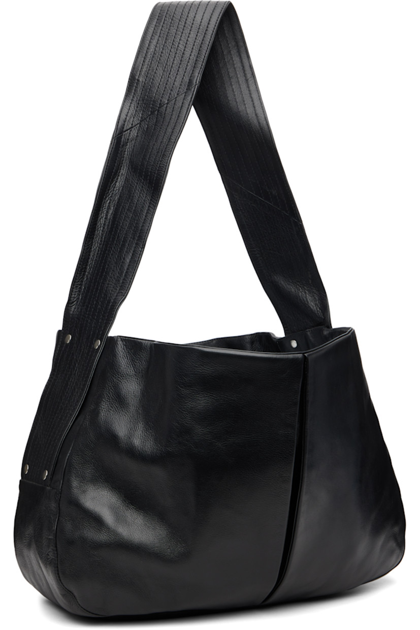 Grained leather messenger bag.

· Fixed quilted shoulder strap
· Inverted box pleat at face and back face
· Press-stud closure
· Patch pocket at interior
· Canvas lining
· H14.5" x W21" x D6.5"

Supplier color: Black
