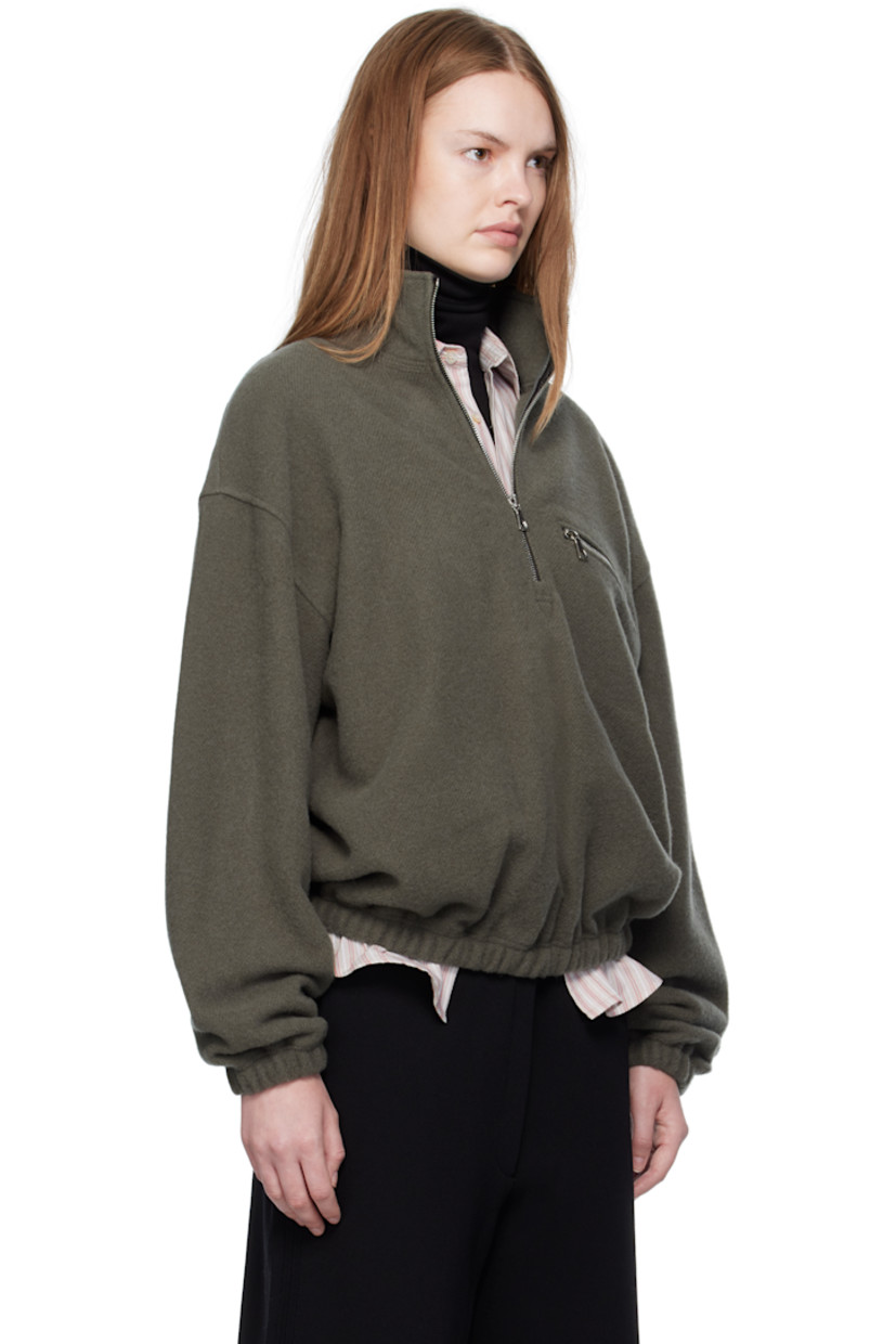 Lightweight virgin wool fleece sweater.

· Stand collar
· Half-zip closure
· Zip pocket at chest
· Elasticized hem and cuffs
· Locker loop at back yoke

Supplier color: Camoscio fleece