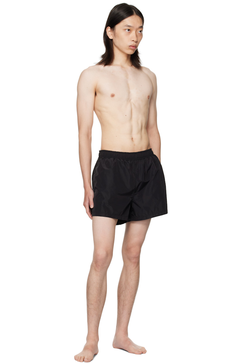 Polyester taffeta swim shorts.

· Drawstring at elasticized waistband
· Three-pocket styling
· Graphic printed at front hem 
· Vented side seams 
· Logo embroidered at back pocket
· Full mesh brief-style lining 

Supplier color: Black