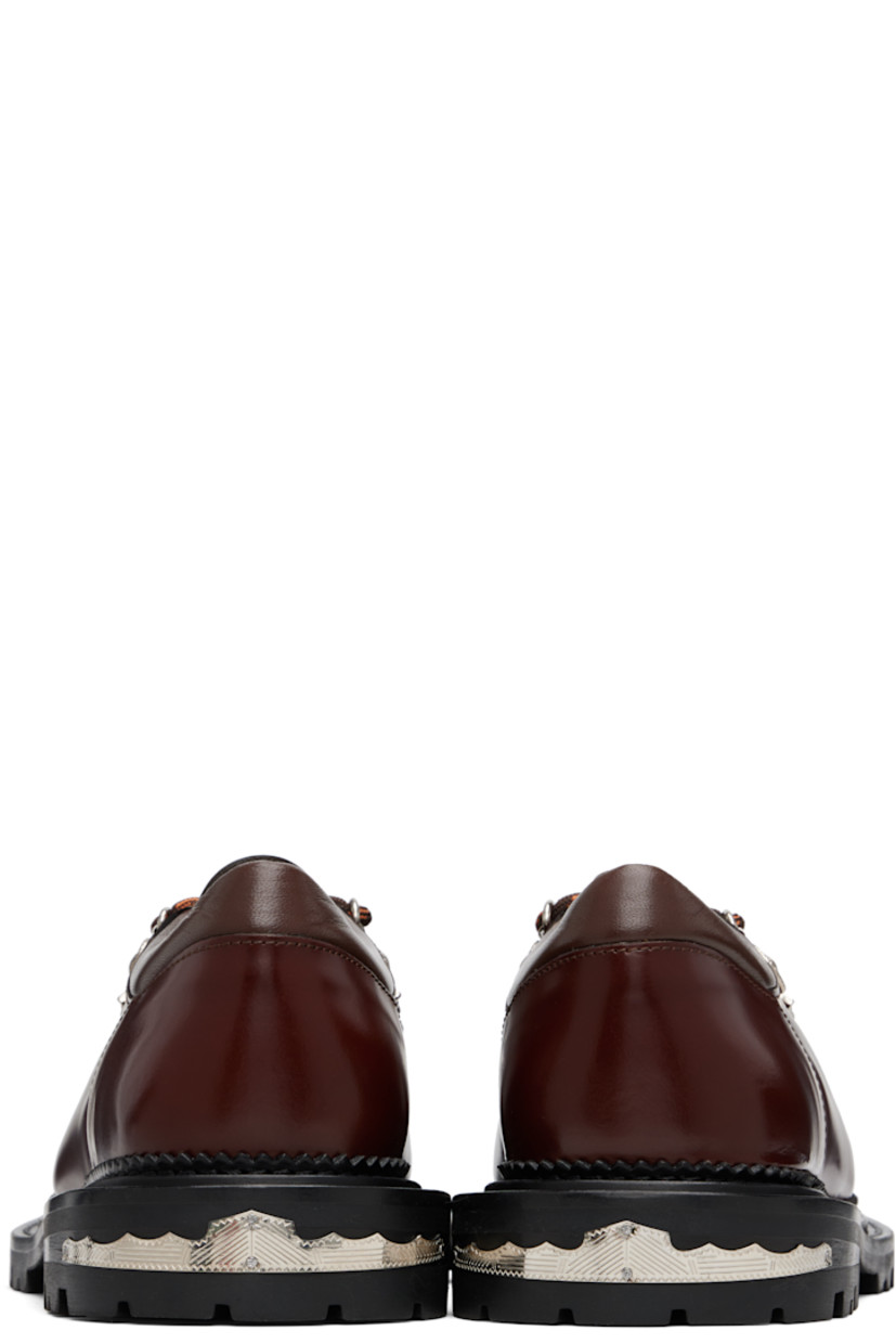 Polished leather derbys.

· Lace-up closure with engraved charms
· Padded leather collar
· Serrated edge at welt
· Etched plaque at heel 
· Treaded rubber sole

Supplier color: Brown