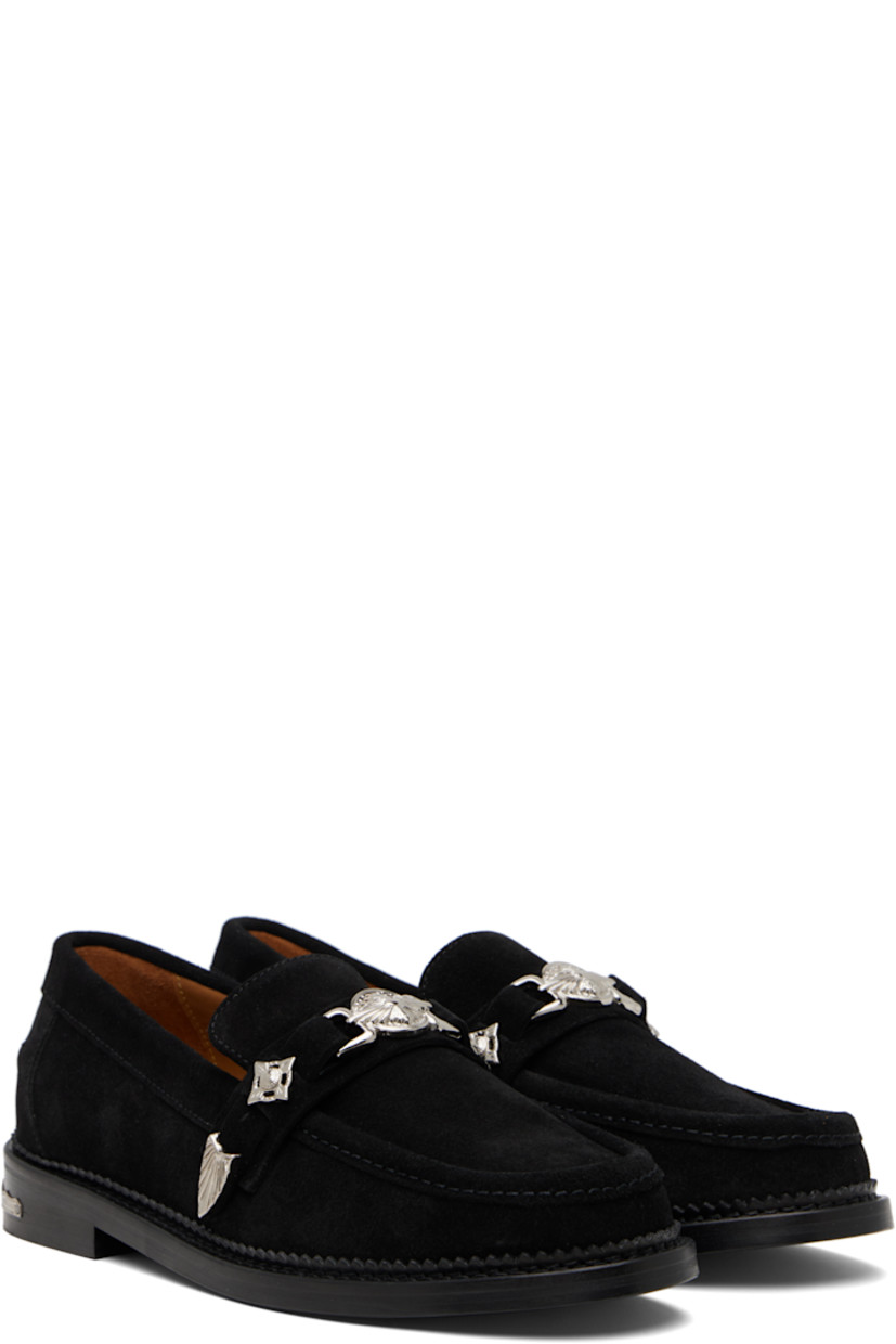Suede loafers.

· Moc toe
· Strap with graphic hardware at vamp
· Pinched seam at heel counter
· Serrated edge at welt
· Buffed leather lining
· Engraved plaque at heel
· Stacked leather heel with rubber injection
· Leather sole

Available exclusively at SSENSE.

Supplier color: Black suede