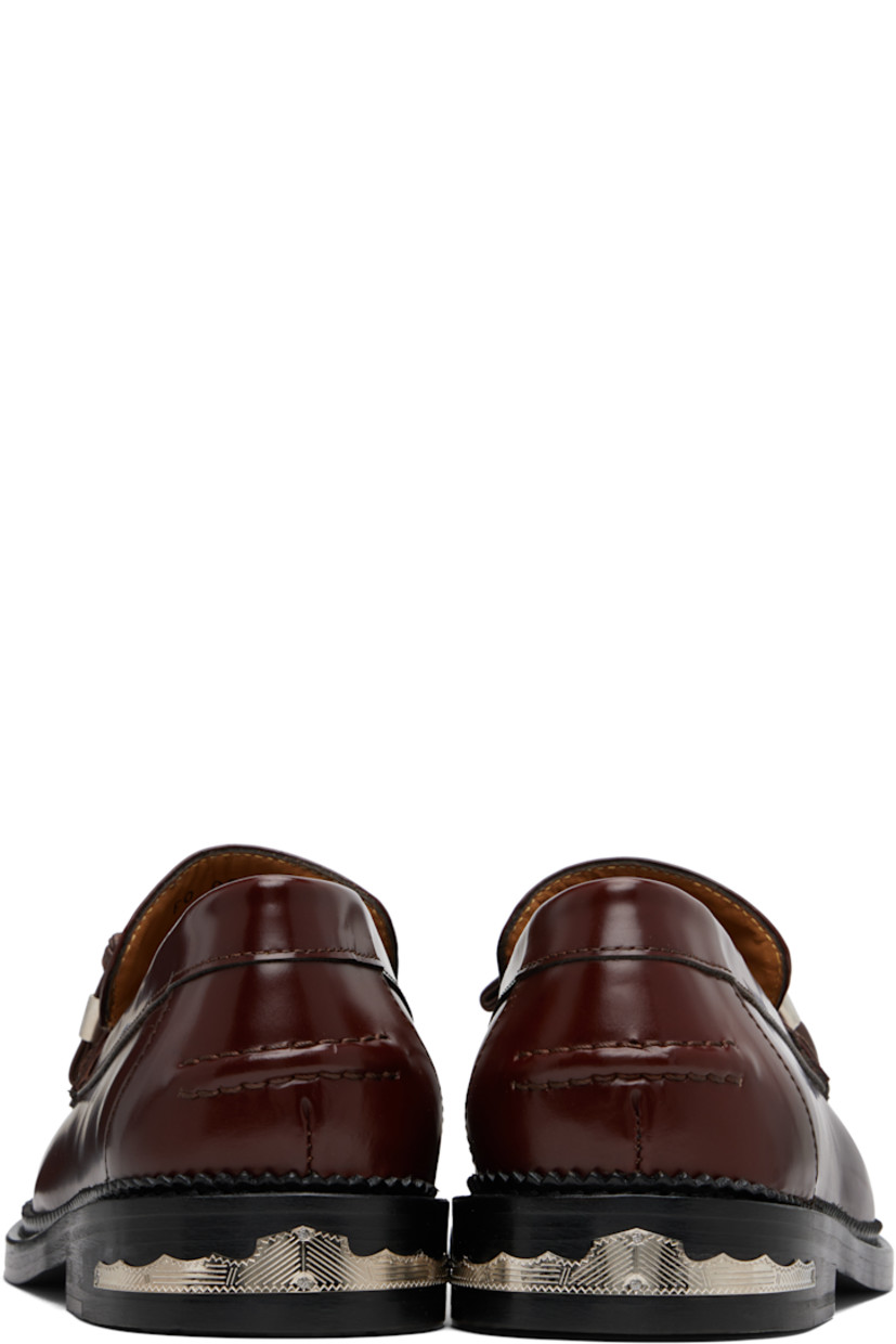 Buffed leather loafers.

· Moc toe
· Knotted strap with O-rings at vamp
· Pinched seam at heel counter
· Serrated edge at welt
· Engraved plaque at heel
· Stacked leather heel with rubber injection
· Leather sole

Supplier color: Brown