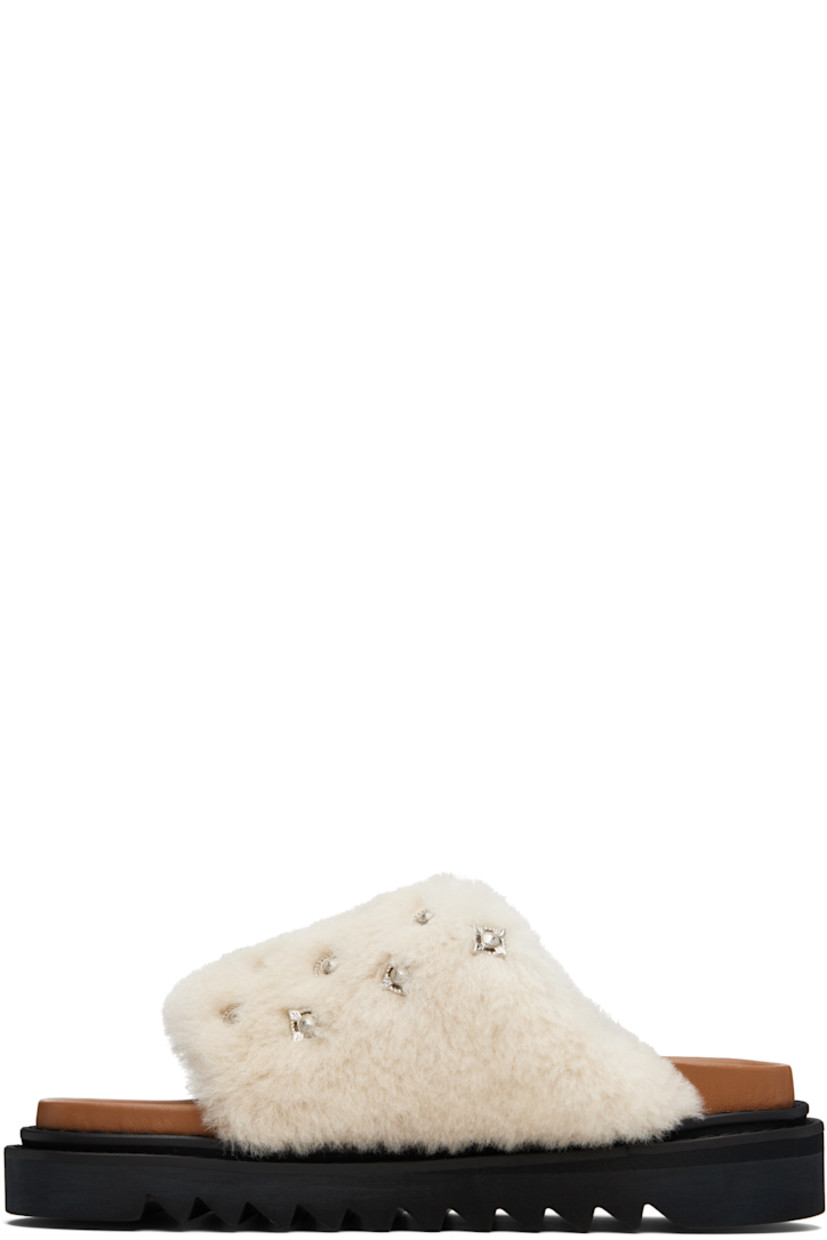 Shearling slip-on sandals.

· Graphic hardware throughout
· Open toe
· Logo stamp at molded footbed
· Buffed leather lining
· Foam rubber midsole
· Treaded rubber sole

Supplier color: Beige