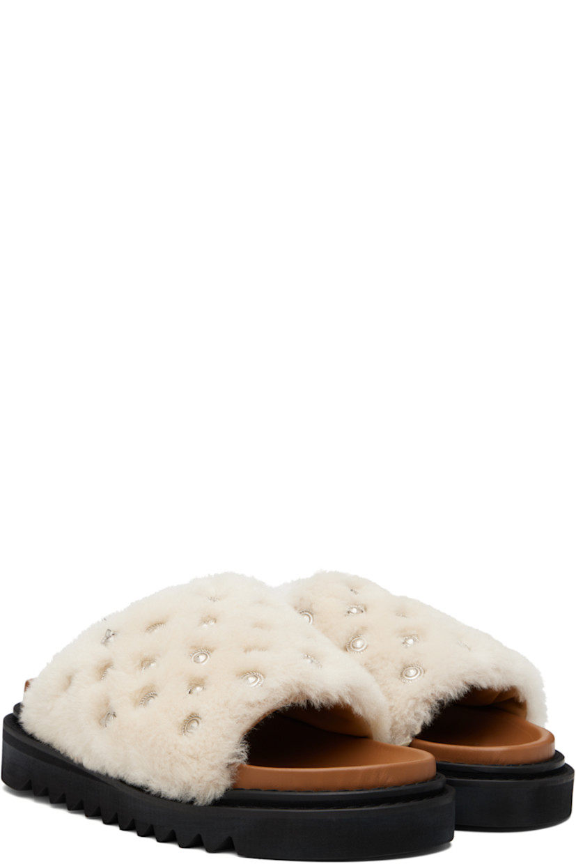 Shearling slip-on sandals.

· Graphic hardware throughout
· Open toe
· Logo stamp at molded footbed
· Buffed leather lining
· Foam rubber midsole
· Treaded rubber sole

Supplier color: Beige