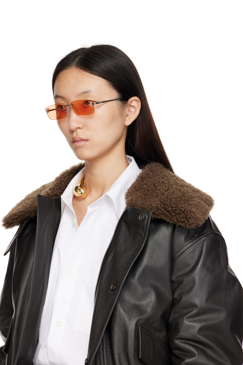 Rectangular rimless metal-frame sunglasses.

· Orange lenses 
· 100% UVA/UVB protection, category 2
· Adjustable rubber nose pads
· Crystal-cut logo at face
· Logo engraved at temples
· Includes pouch
· Size: 54.16 135 

Supplier color: Shiny palladium/