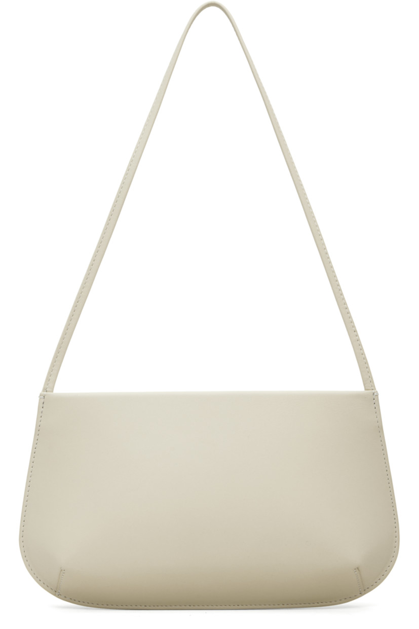 Buffed calfskin shoulder bag.

· Fixed shoulder strap
· Darts at base
�· Magnetic closure
· Patch pocket at interior
· Twill lining
· H6" x W11" x D2.25"

Supplier color: Tofu calf