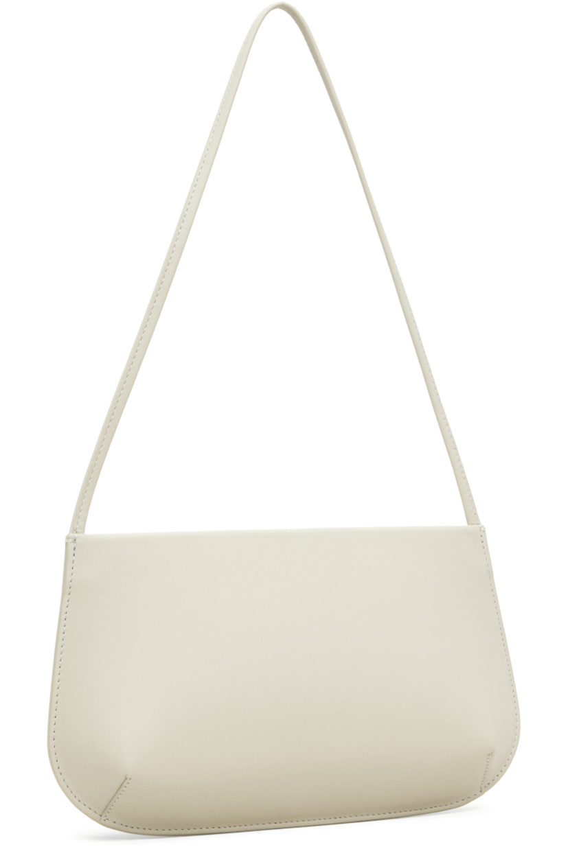 Buffed calfskin shoulder bag.

· Fixed shoulder strap
· Darts at base
· Magnetic closure
· Patch pocket at interior
· Twill lining
· H6" x W11" x D2.25"

Supplier color: Tofu calf