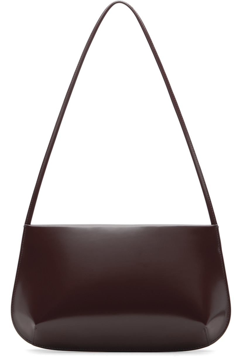 Spazzolato calfskin shoulder bag.

· Fixed shoulder strap
· Darts at base
· Magnetic closure
· Patch pocket at interior
· Twill lining
· H6" x W11" x D2.25"

Supplier color: Choc spazzolato