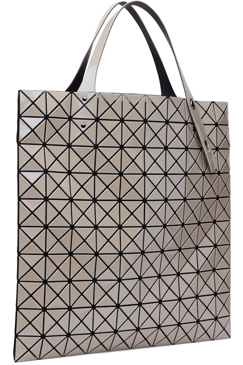 Mesh tote in black. Signature triangular vinyl appliqués in metallic gray throughout.

· Adjustable twin shoulder straps
· Open throat
· Zip pocket at interior
· Unlined 
· H15.5" x W15.5"

Supplier color: Greige