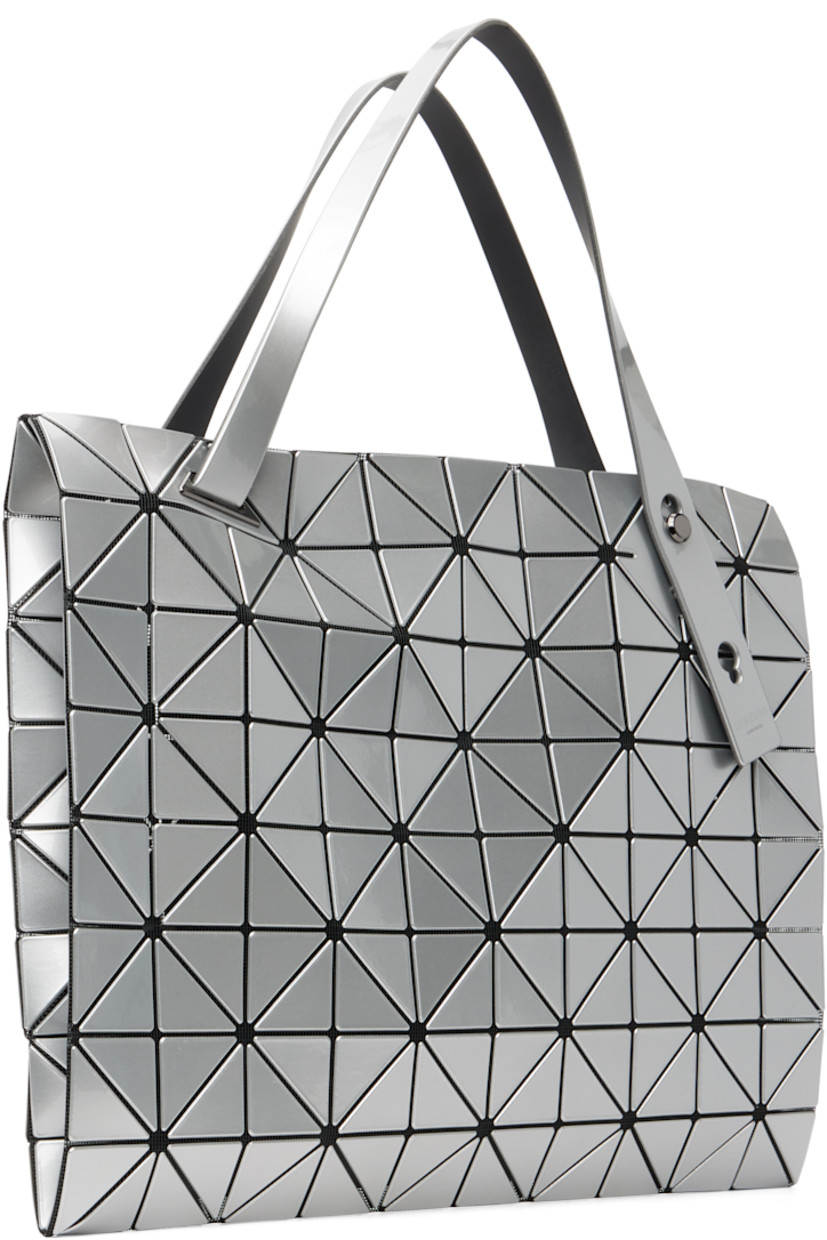 Mesh tote.

· Signature triangular vinyl appliqués in silver tone throughout
· Adjustable shoulder straps
· Two-way zip closure
· Zip pocket at interior
· H12.5" x W12.5"

Supplier color: Silver