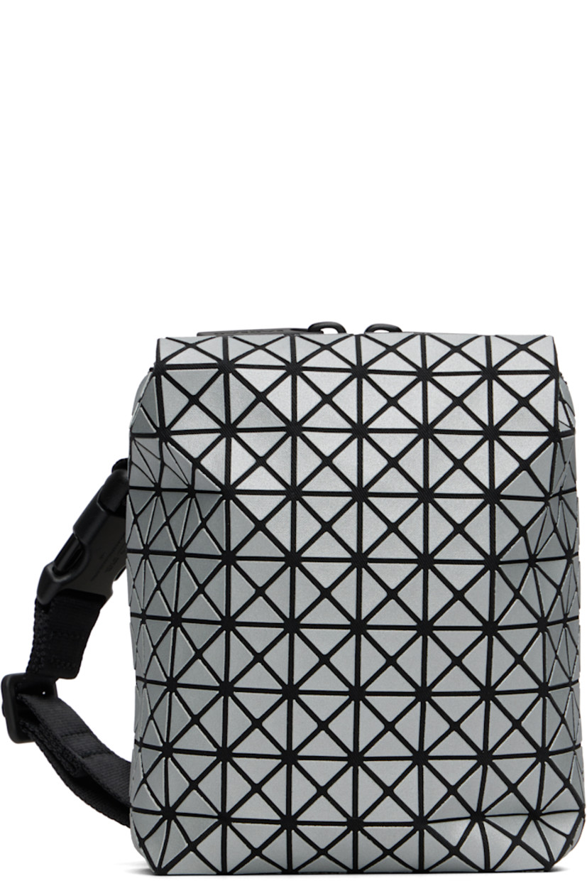 Twill messenger bag.

· Triangular reflective vinyl appliqués throughout
· Adjustable and detachable crossbody strap
· Patch pocket at back face
· Two-way zip closure
· Clasp at two-compartment interior
· Zip pocket and three card slots
· H6" x W5" x D2"

Supplier color: Silver