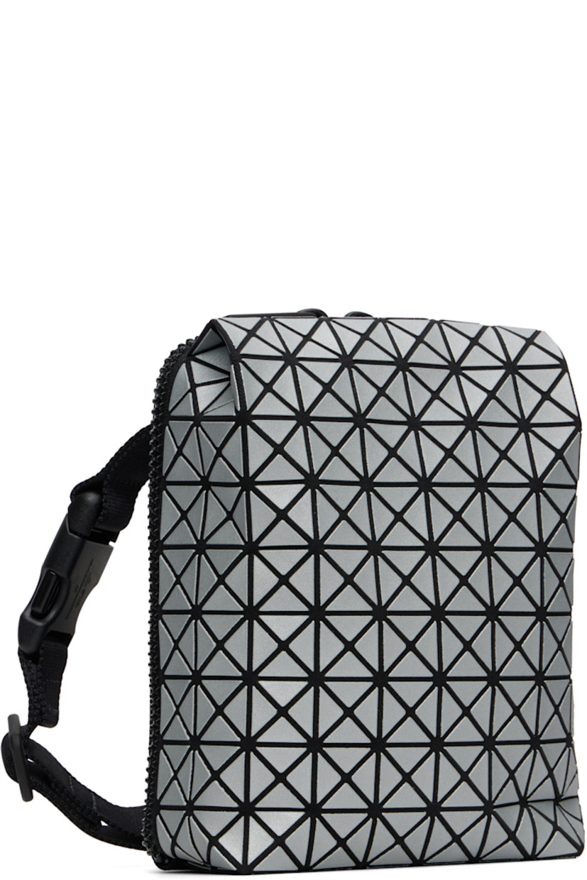Twill messenger bag.

· Triangular reflective vinyl appliqués throughout
· Adjustable and detachable crossbody strap
· Patch pocket at back face
· Two-way zip closure
· Clasp at two-compartment interior
· Zip pocket and three card slots
· H6" x W5" x D2"

Supplier color: Silver