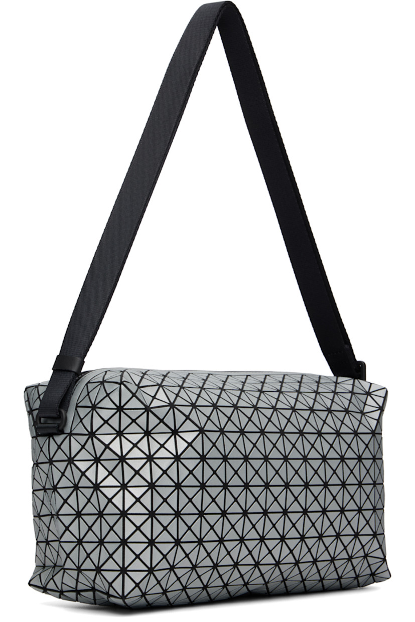 Twill messenger bag.

· Triangular reflective vinyl appliqués throughout
· Adjustable crossbody strap
· Zip closure
· Zip pocket at interior
· H5.5" x W11" x D6"

Supplier color: Silver