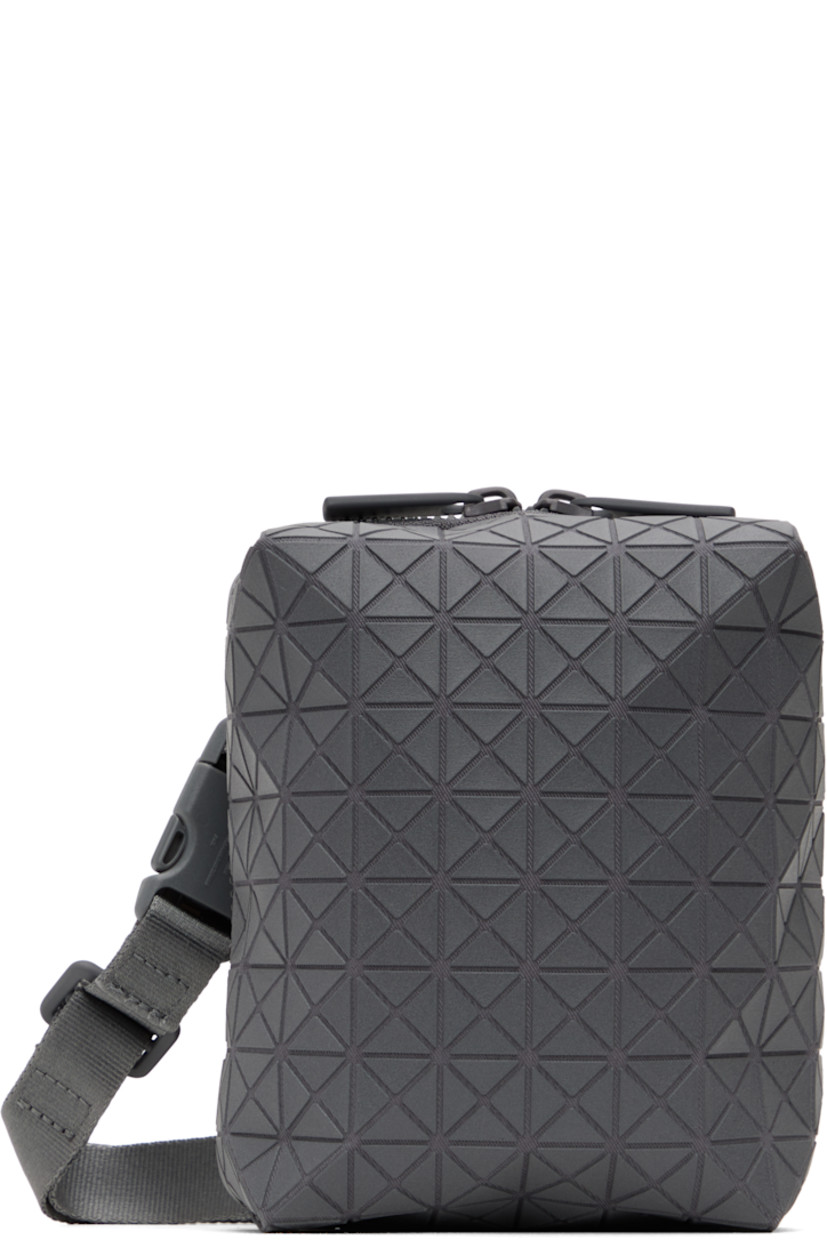 Twill messenger bag in gray.

· Triangular polymer appliqués throughout
· Adjustable and detachable crossbody strap
· Patch pocket at back face
· Two-way zip closure
· Clasp at two-compartment interior
· Zip pocket and three card slots
· H6" x W5" x D2"

Supplier color: One-tone gray