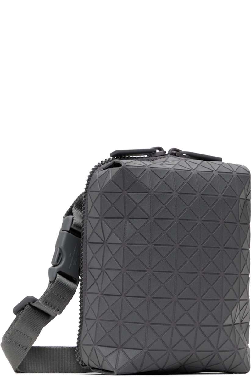 Twill messenger bag in gray.

· Triangular polymer appliqués throughout
· Adjustable and detachable crossbody strap
· Patch pocket at back face
· Two-way zip closure
· Clasp at two-compartment interior
· Zip pocket and three card slots
· H6" x W5" x D2"

Supplier color: One-tone gray