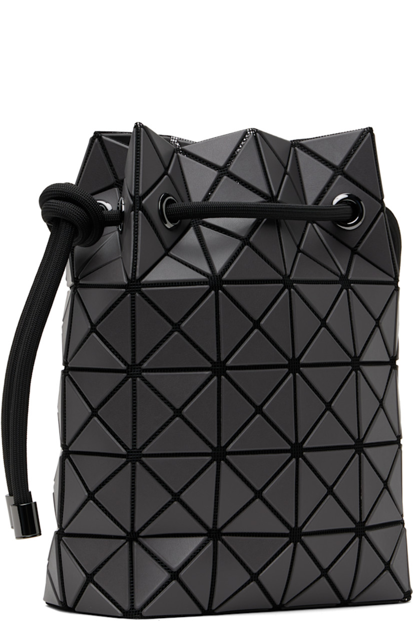 Mesh messenger bag in black. 

· Triangular faux-leather appliqués in gray throughout
· Adjustable drawstring shoulder strap
· Open throat
· Zip pocket at interior
· Patterned textile lining
· H9" x W8" x D3.5"

Supplier color: Charcoal