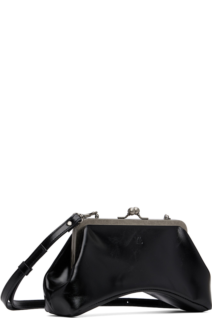 Rigid buffed leather shoulder bag.

· Adjustable and detachable crossbody strap
· Logo embossed at face
· Curved base
· Kiss-lock closure
· Patch pocket at interior
· Twill lining
· H5" x W9" x D3.25"

Supplier color: Black