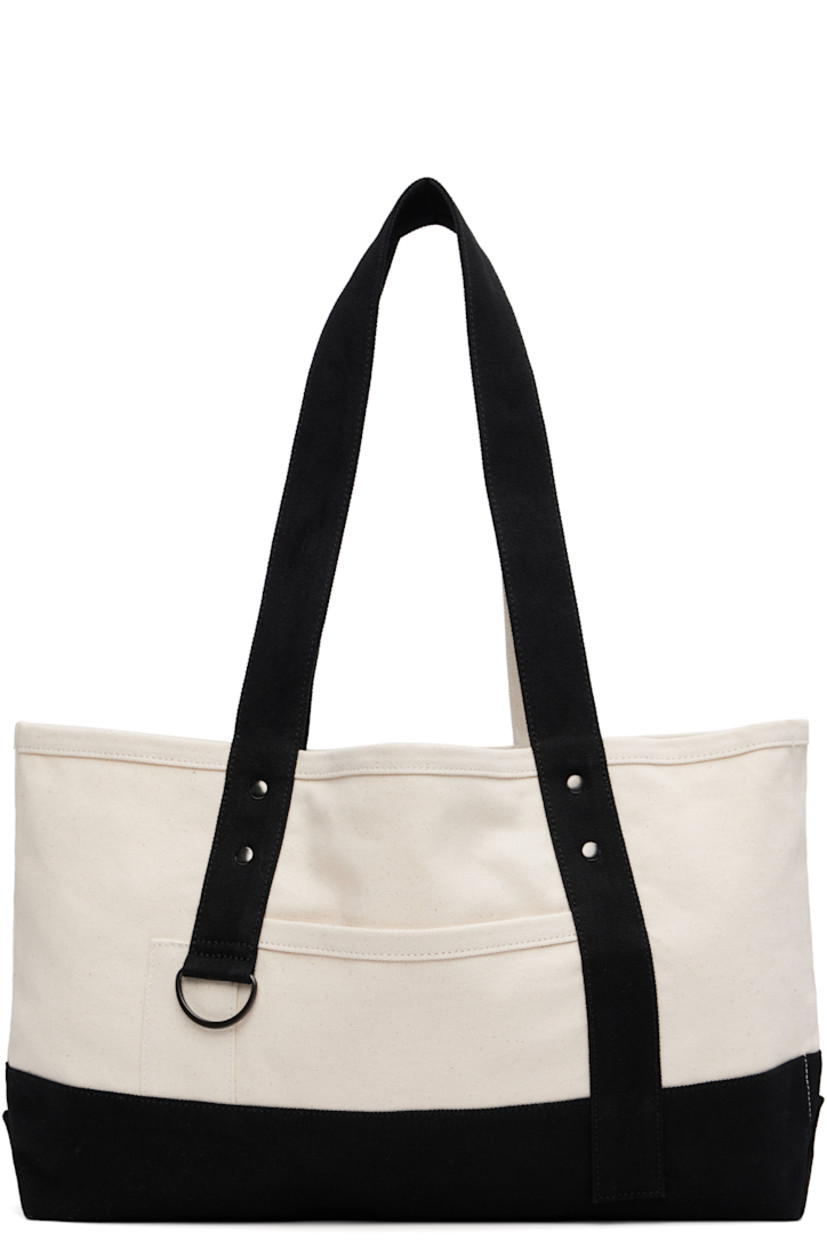 Cotton canvas tote.

· Fixed twin shoulder straps
· D-ring at face
· Patch pocket at face and back face
· Press-stud closure
· Bottle sleeve at interior
· Unlined
· H9.5" x W18" x D4"

Supplier color: Off white