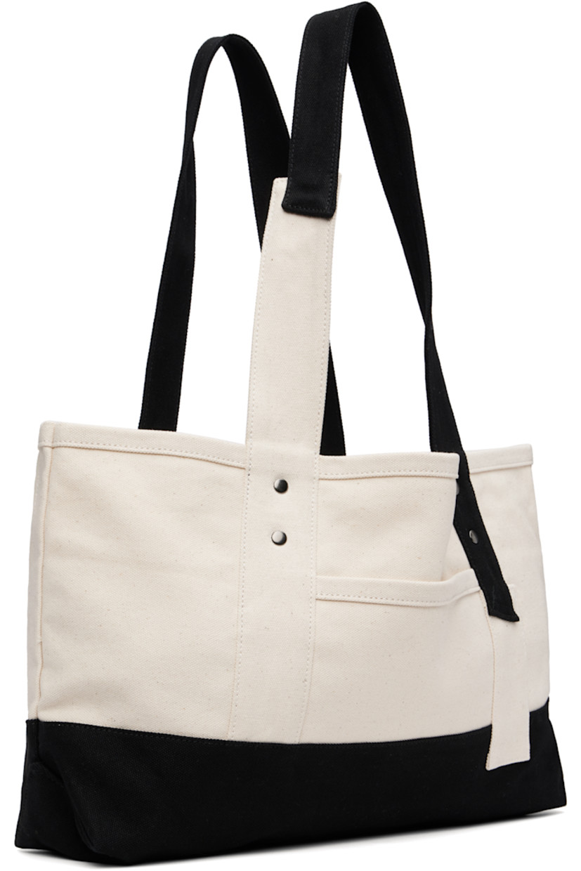 Cotton canvas tote.

· Fixed twin shoulder straps
· D-ring at face
· Patch pocket at face and back face
· Press-stud closure
· Bottle sleeve at interior
· Unlined
· H9.5" x W18" x D4"

Supplier color: Off white