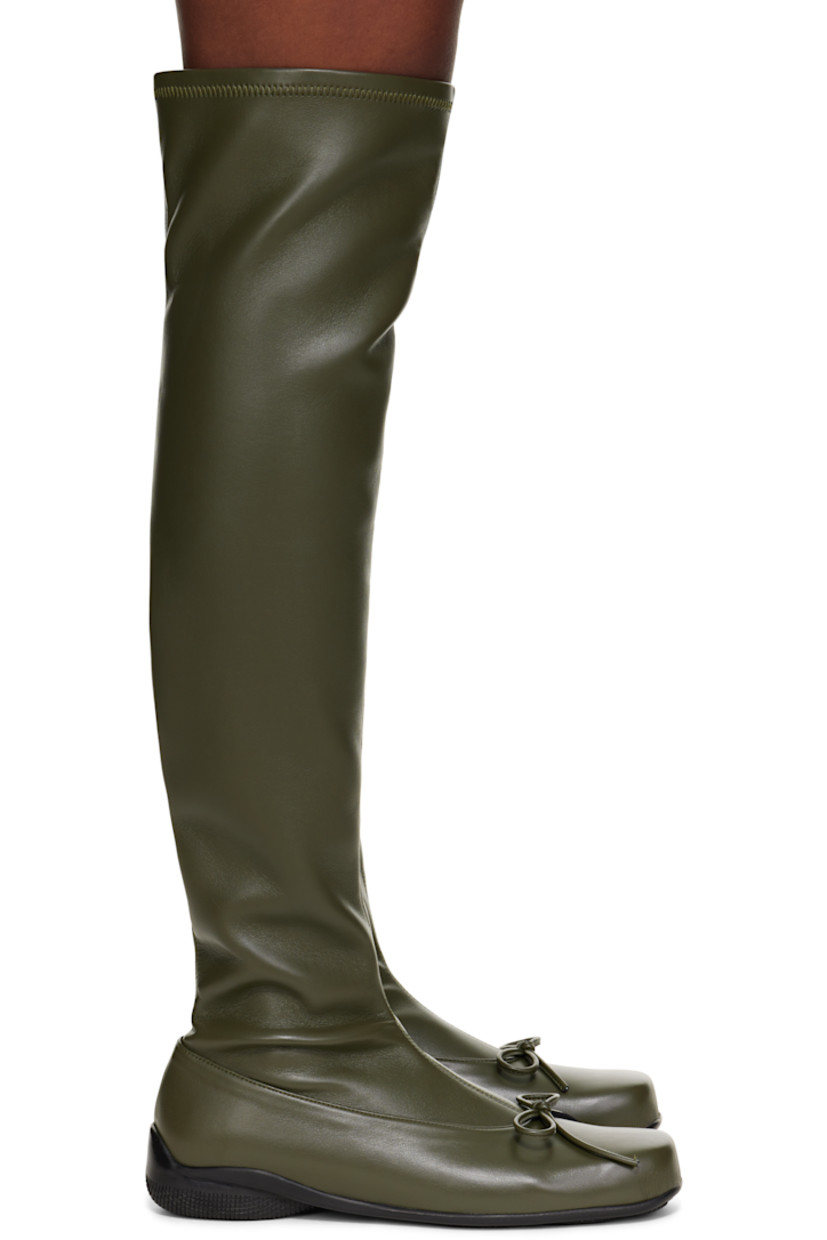 Thigh-high grained faux-leather boots. 

· Square toe 
· Bow accent at vamp
· Treaded rubber sole

Supplier color: Khaki