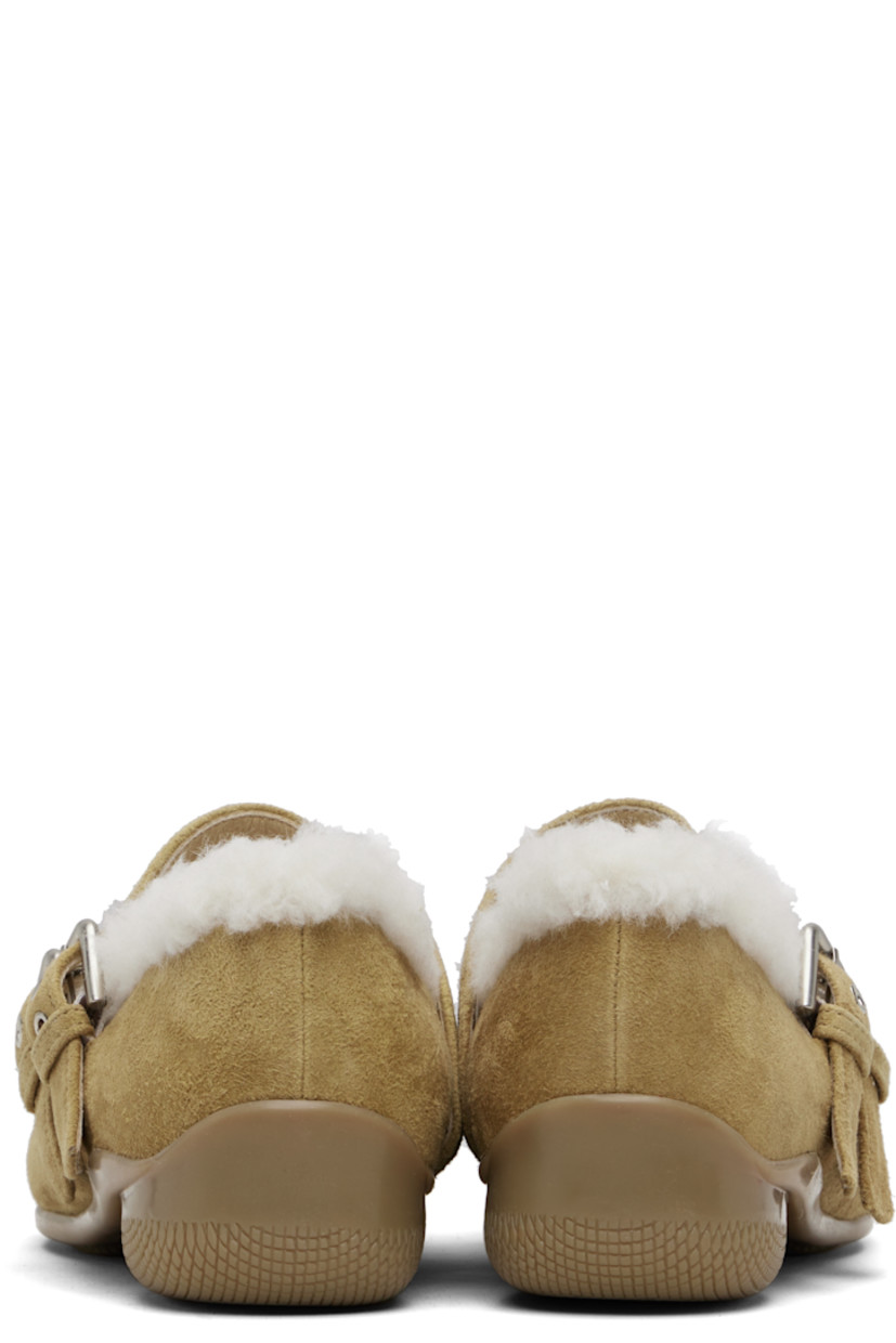 Suede Mary Jane-style flats.

· Square toe
· Studs and bow accent at vamp
· Pin-buckle straps at vamp
· Shearling lining
· Treaded rubber sole

Supplier color: Brown