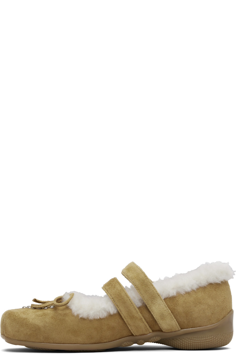 Suede Mary Jane-style flats.

· Square toe
· Studs and bow accent at vamp
· Pin-buckle straps at vamp
· Shearling lining
· Treaded rubber sole

Supplier color: Brown