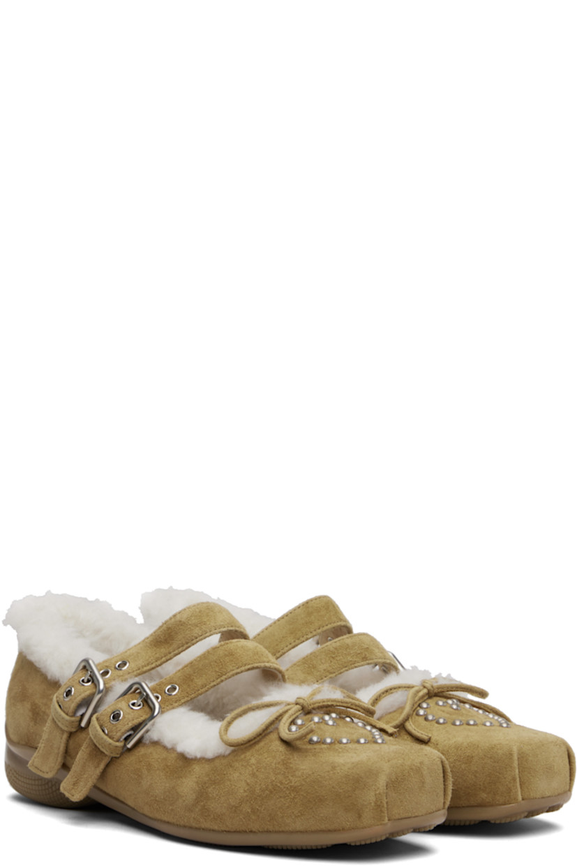 Suede Mary Jane-style flats.

· Square toe
· Studs and bow accent at vamp
· Pin-buckle straps at vamp
· Shearling lining
· Treaded rubber sole

Supplier color: Brown