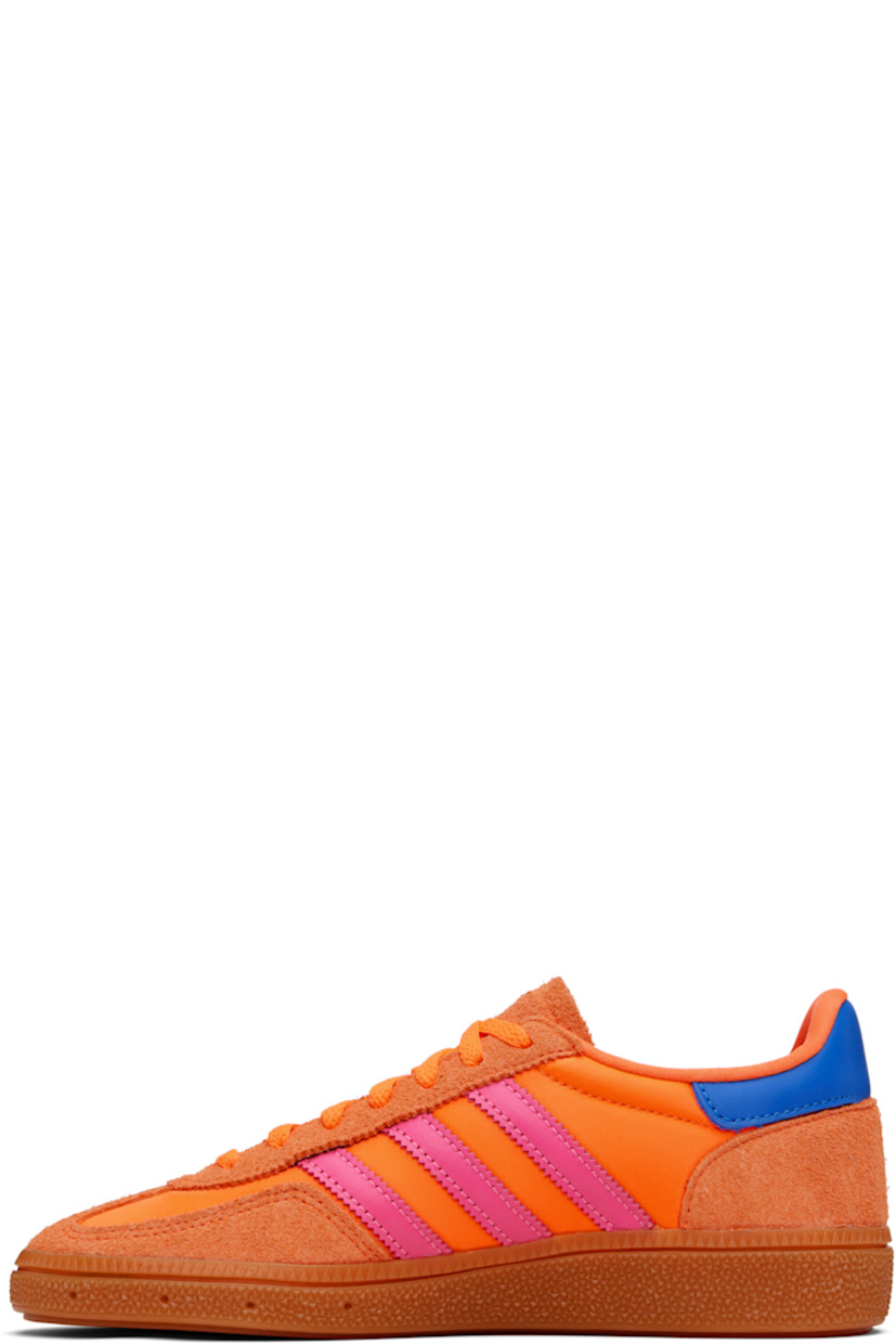Low-top satin sneakers.

· Suede trim throughout
· Lace-up closure
· Logo patch at tongue
· Padded collar
· Signature serrated stripes at sides
· Text bonded at outer side
· Jersey lining
· Logo embossed at textured rubber midsole
· Treaded rubber sole

Supplier color: Solar orange/Lucid pink/Gum