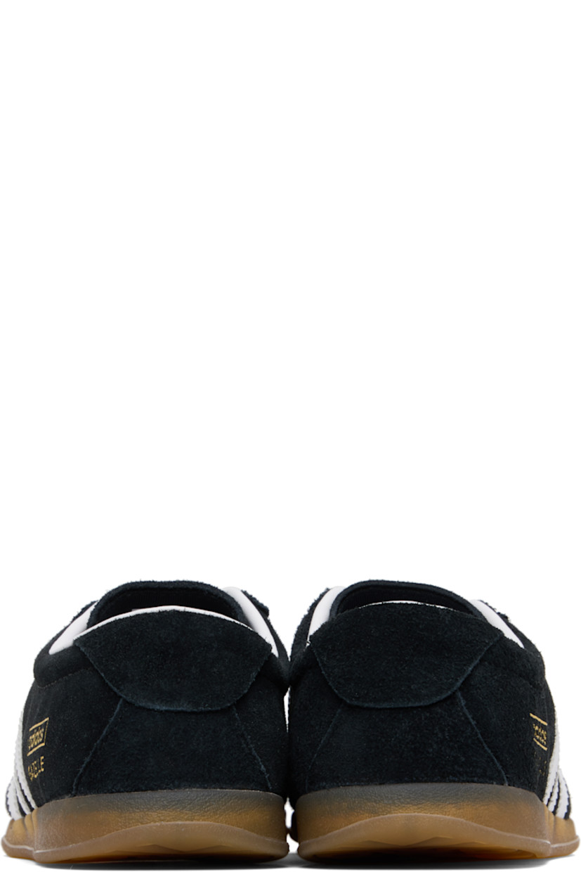 Low-top faux-suede sneakers.

· Lace-up closure
· Logo printed at tongue
· Padded collar
· Signature serrated stripes at sides
· Text stamp at outer side
· Grained faux-leather lining
· Treaded rubber sole

Supplier color: Black/White/Gum