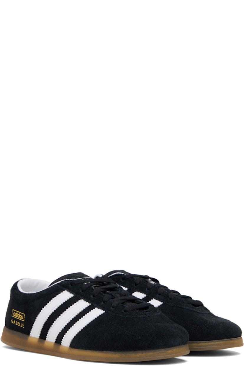 Low-top faux-suede sneakers.

· Lace-up closure
· Logo printed at tongue
· Padded collar
· Signature serrated stripes at sides
· Text stamp at outer side
· Grained faux-leather lining
· Treaded rubber sole

Supplier color: Black/White/Gum